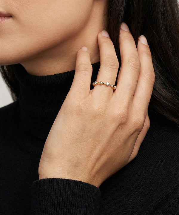 Close-up of a hand wearing a silver ring with a blurred background
