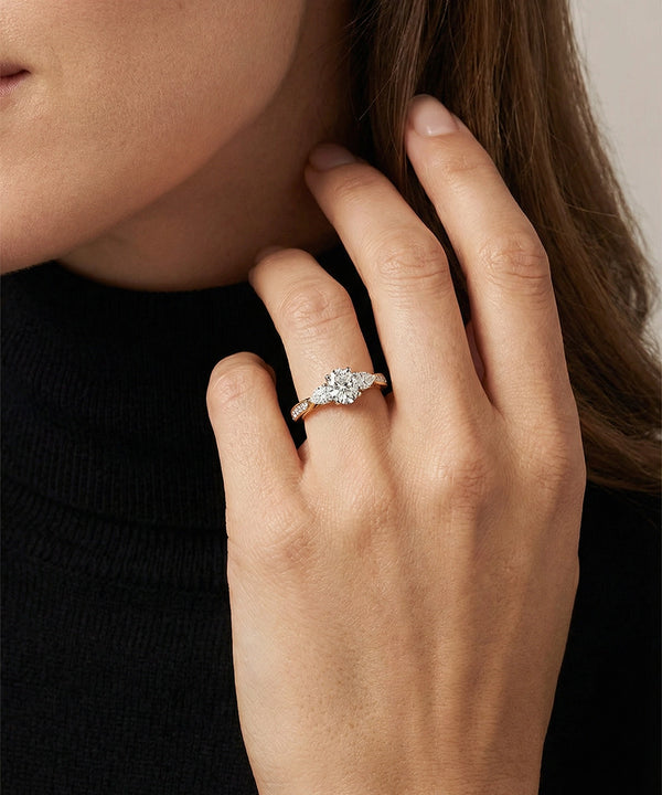 Close-up of a hand wearing a diamond ring with a blurred background