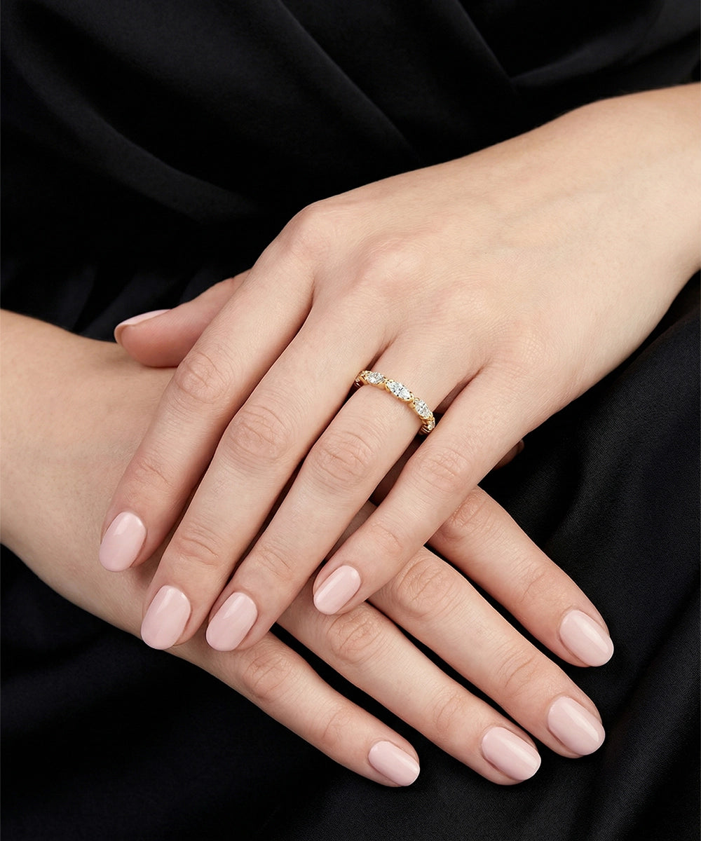 Close-up of a hand wearing a diamond ring on a black background