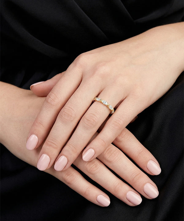 Close-up of a hand wearing a diamond ring on a black background