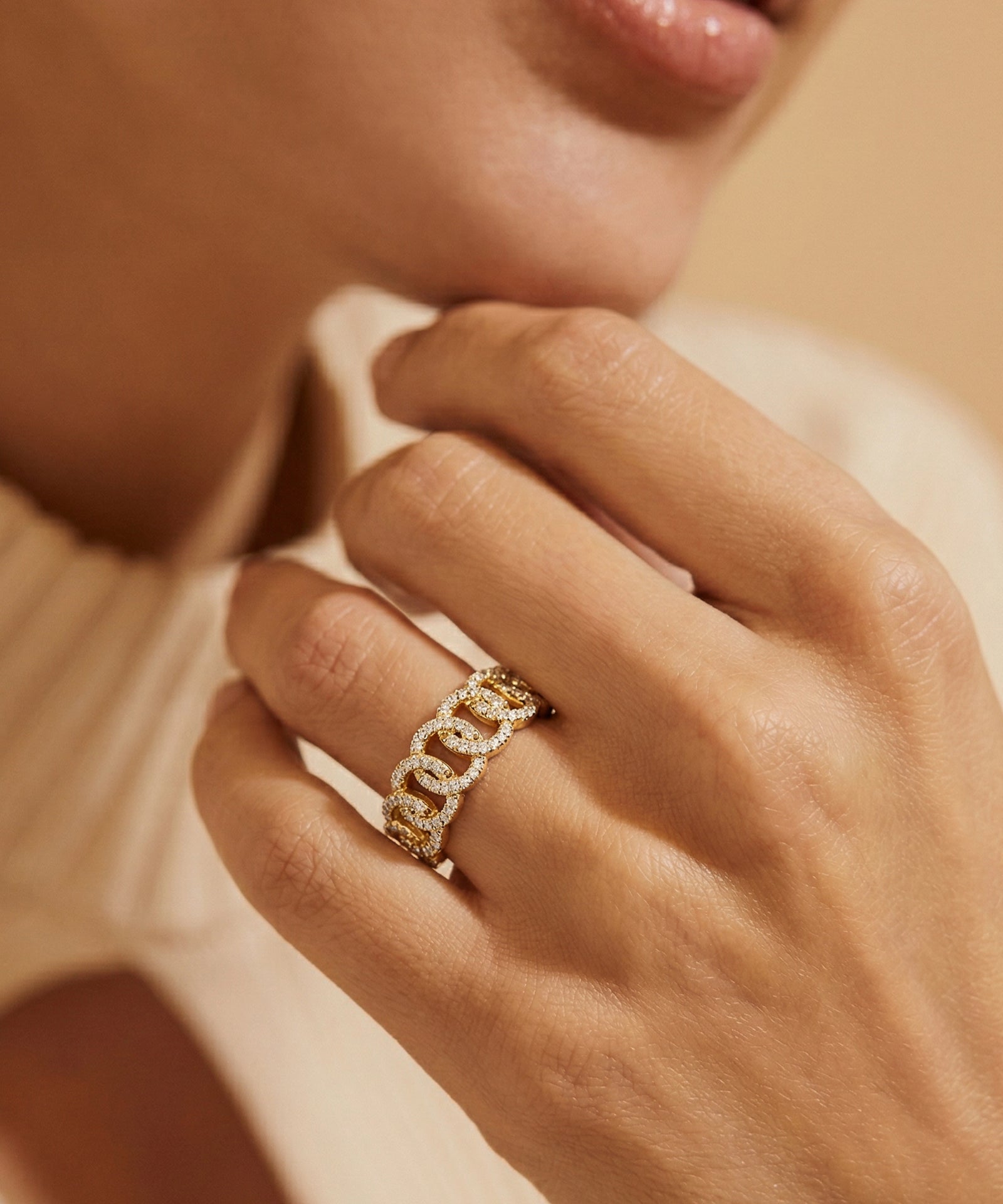 Close-up of a hand wearing a gold ring with a blurred background