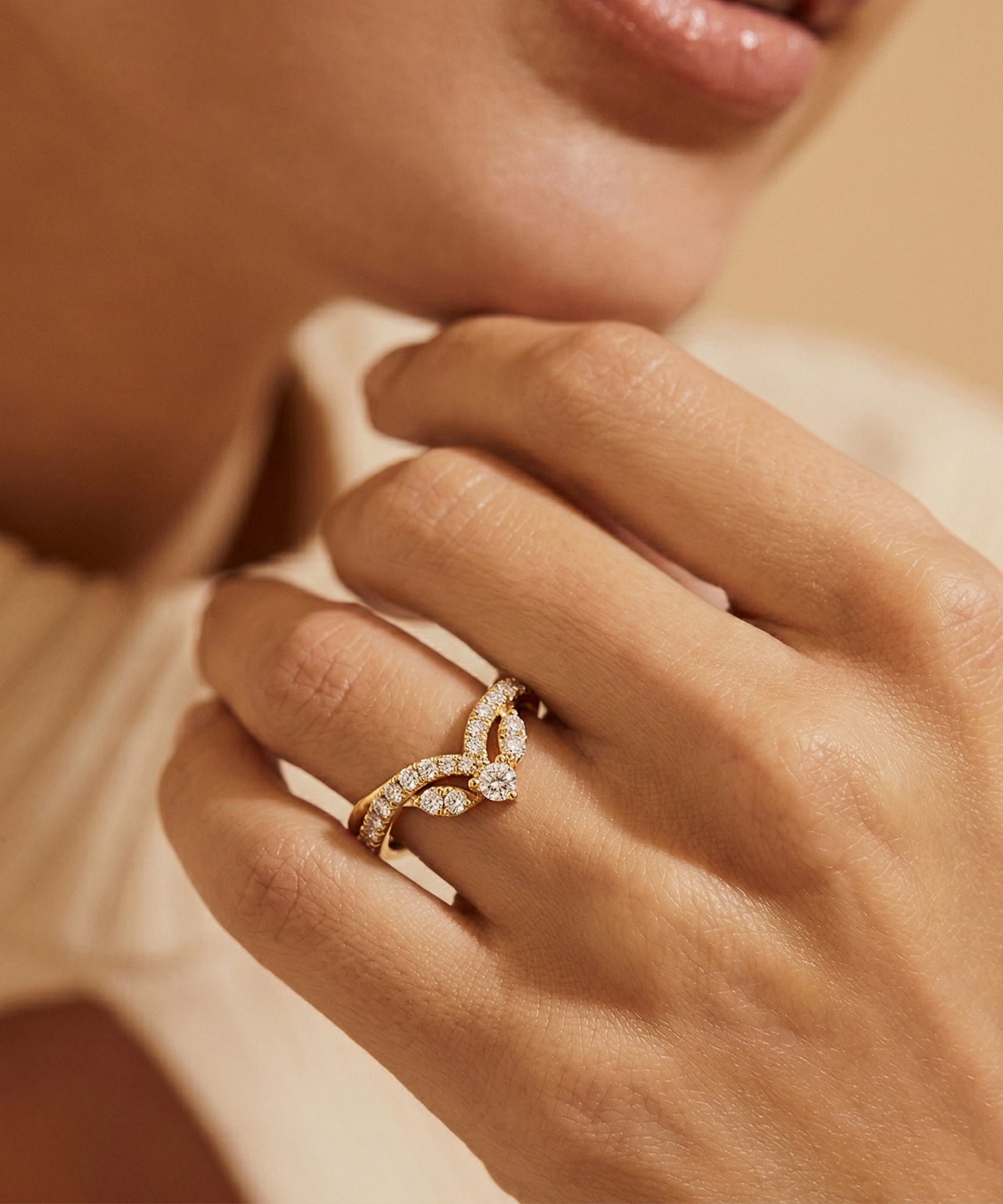 Close-up of a hand wearing a gold ring with diamond accents.