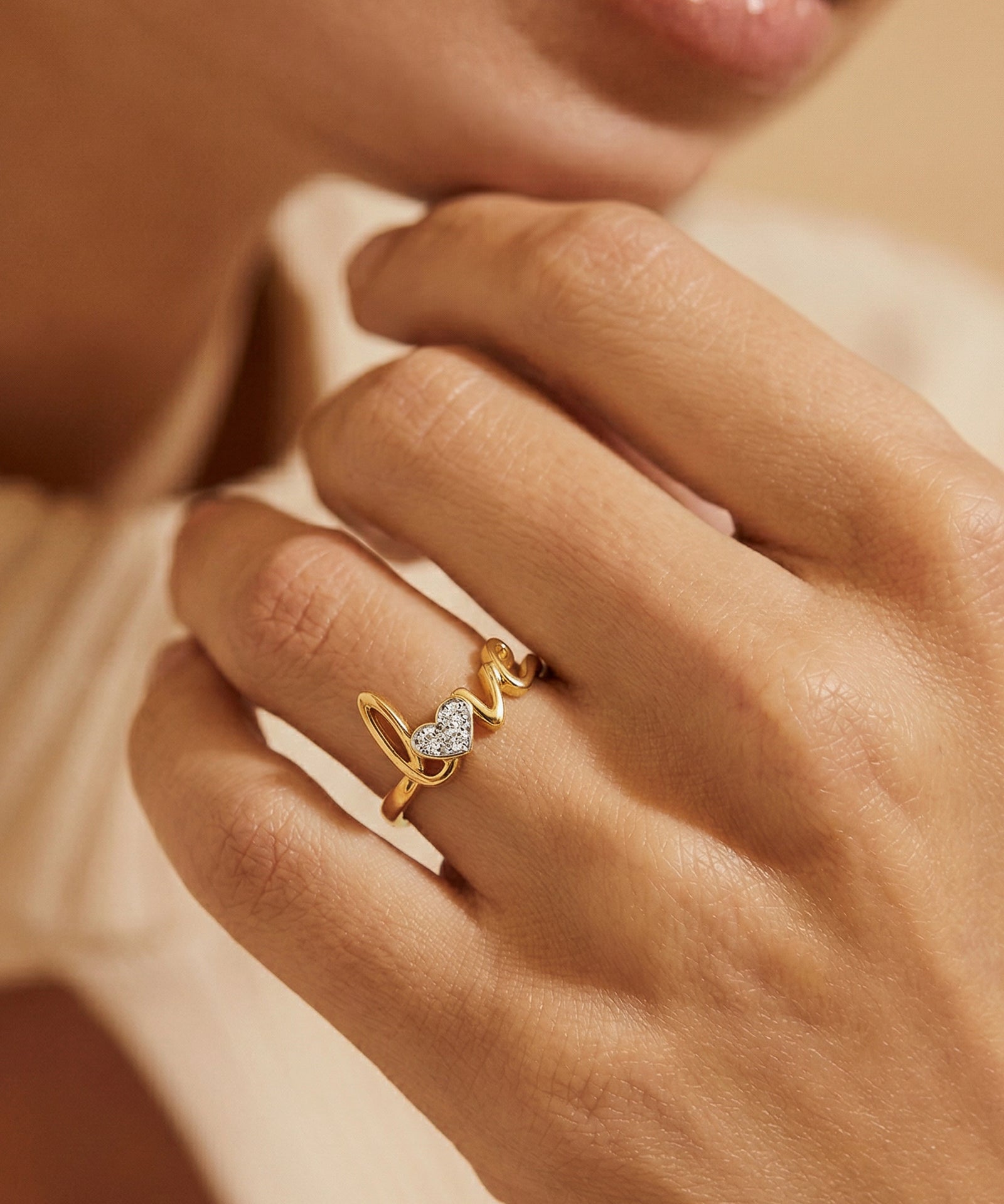 Gold ring with a heart-shaped diamond on a hand