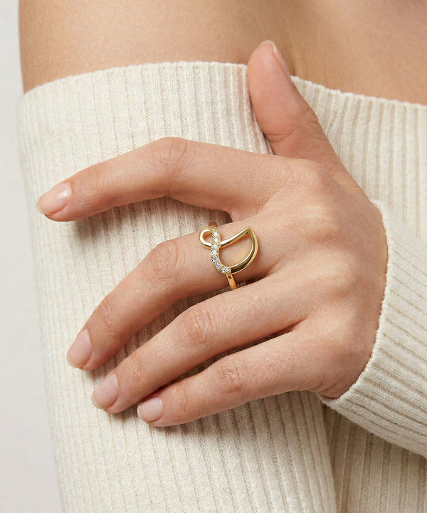Hand wearing a gold ring with a white background