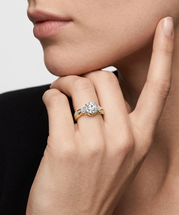 Close-up of a hand wearing a gold ring with a diamond on a neutral background