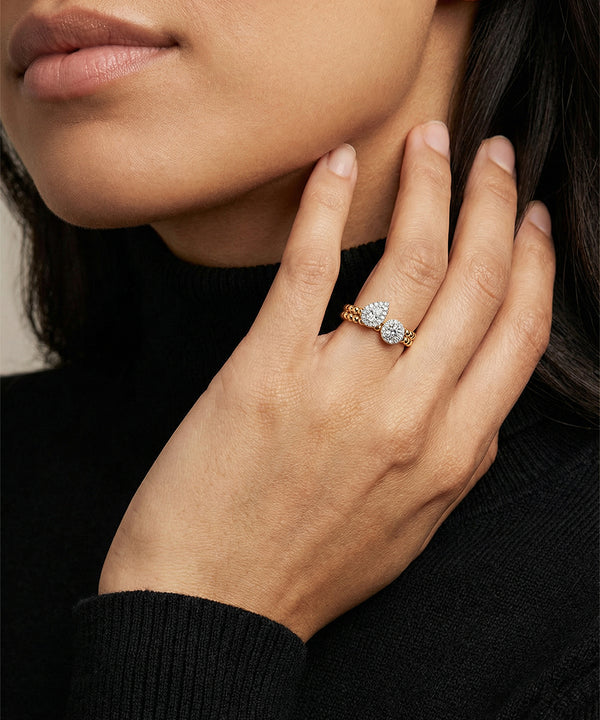Close-up of a hand wearing a diamond ring with a blurred background