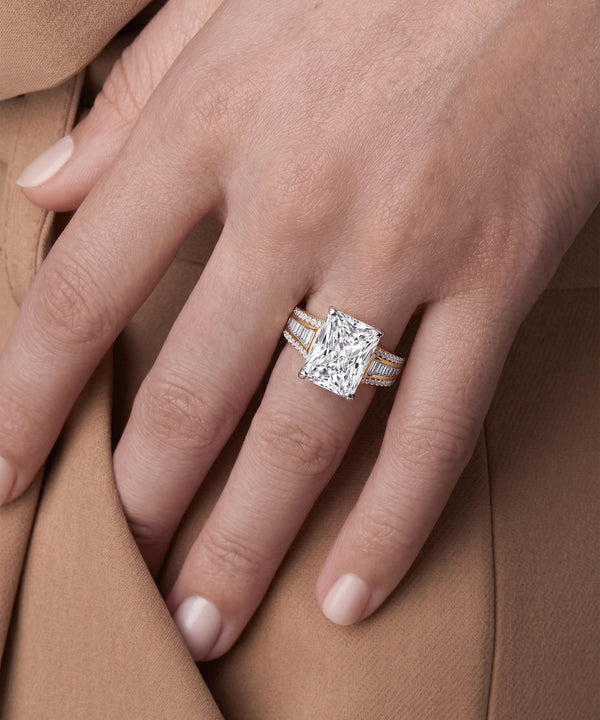 Close-up of a hand wearing a diamond ring on a brown fabric background