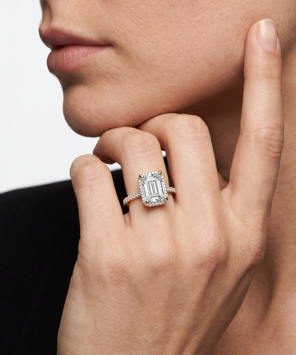 Close-up of a hand wearing a diamond ring with a white background