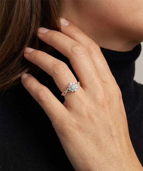 Close-up of a hand wearing a diamond ring with a blurred background