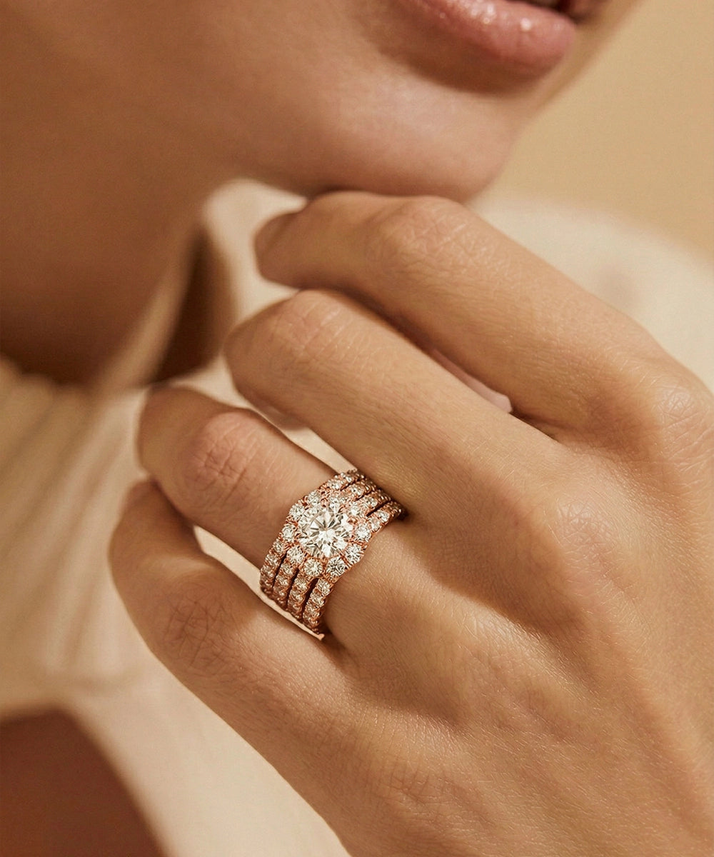 Rose gold ring with diamonds on a hand against a soft background