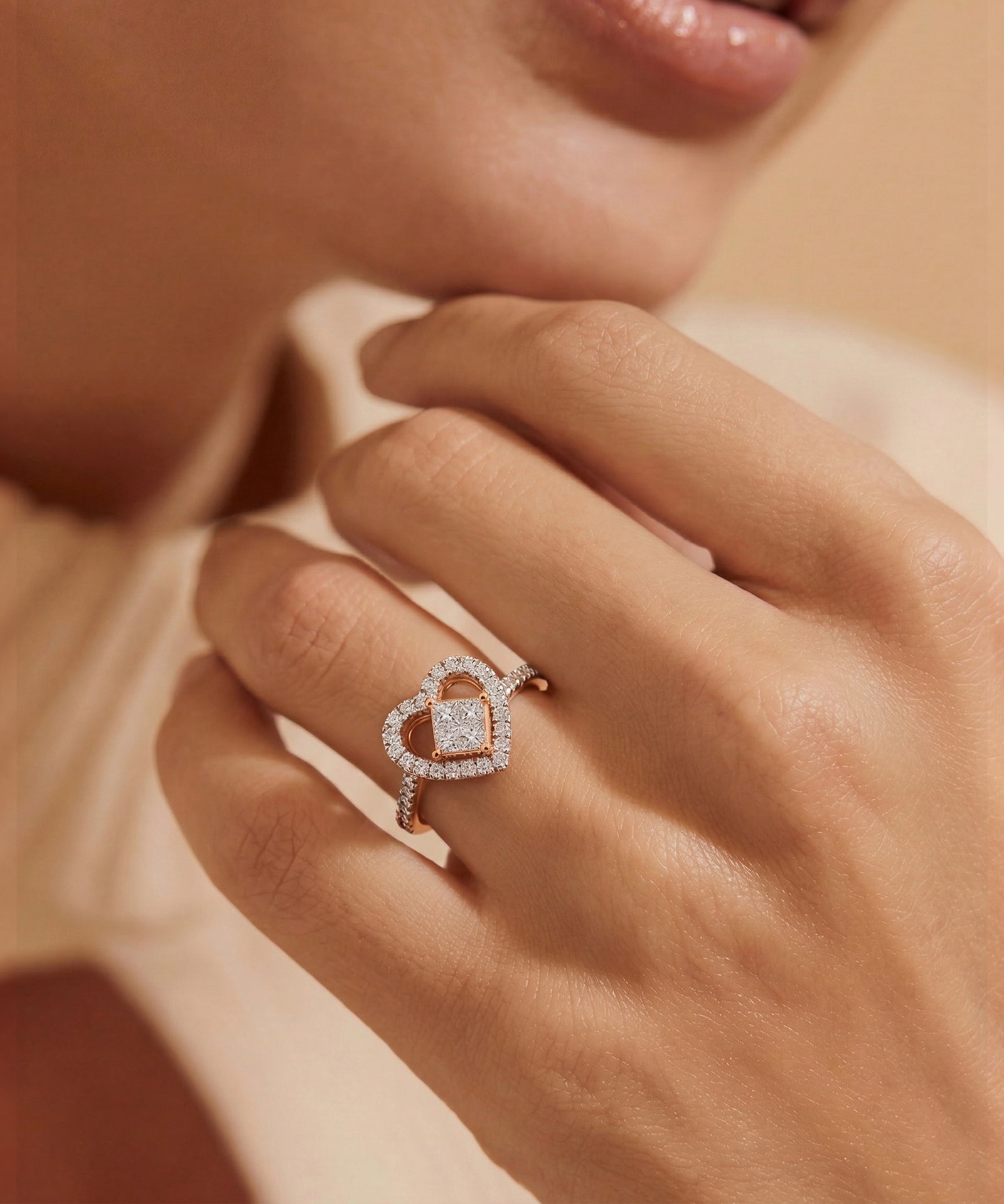 Close-up of a hand wearing a rose gold ring with a diamond design.