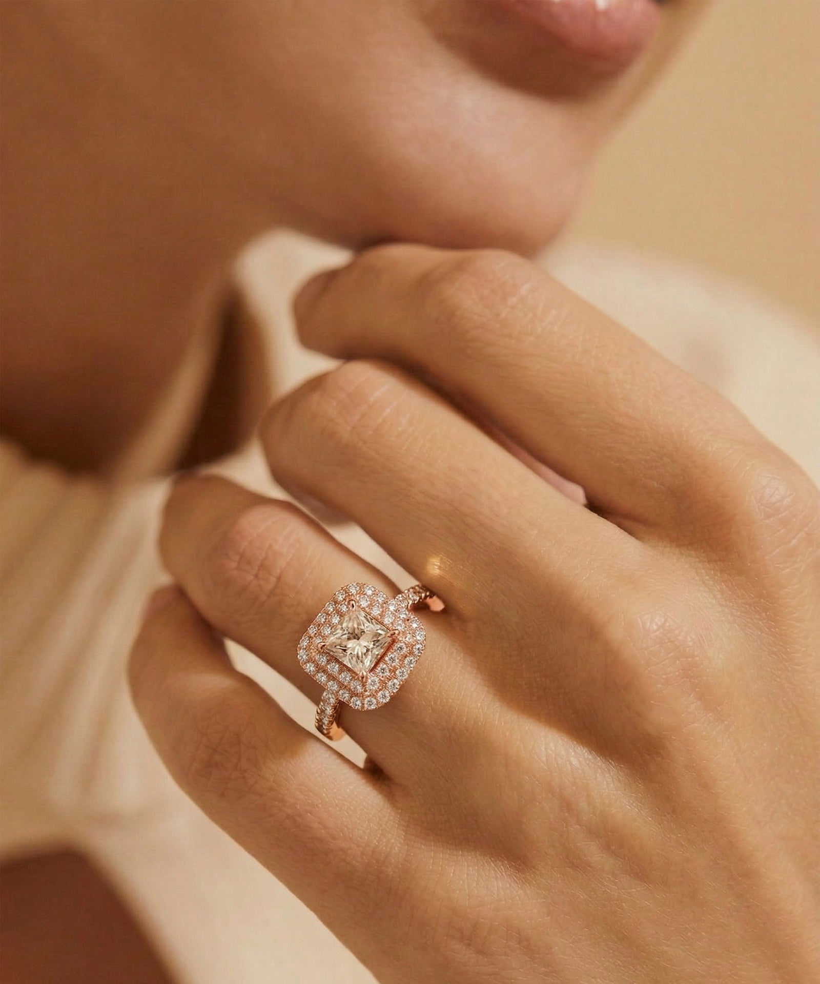 Close-up of a hand wearing a rose gold diamond ring with a soft focus background