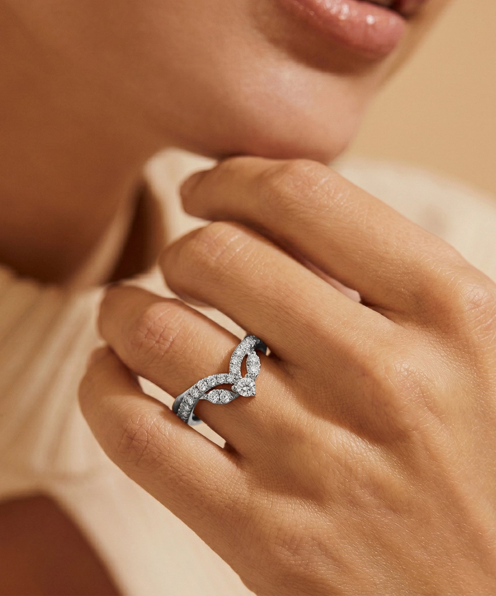 Close-up of a hand wearing a diamond ring with a soft focus background