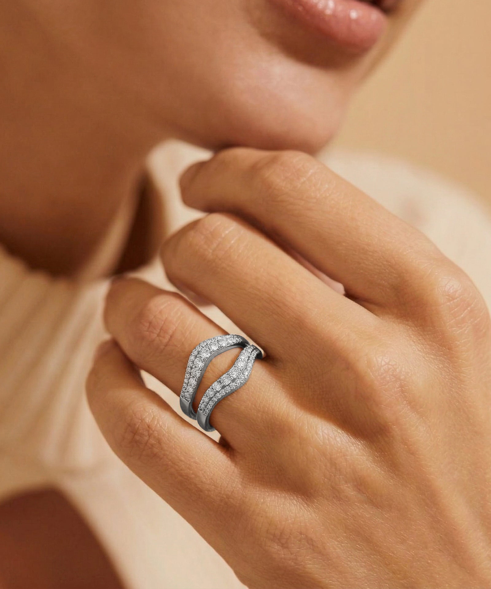 Close-up of a hand wearing a diamond ring with a soft focus background