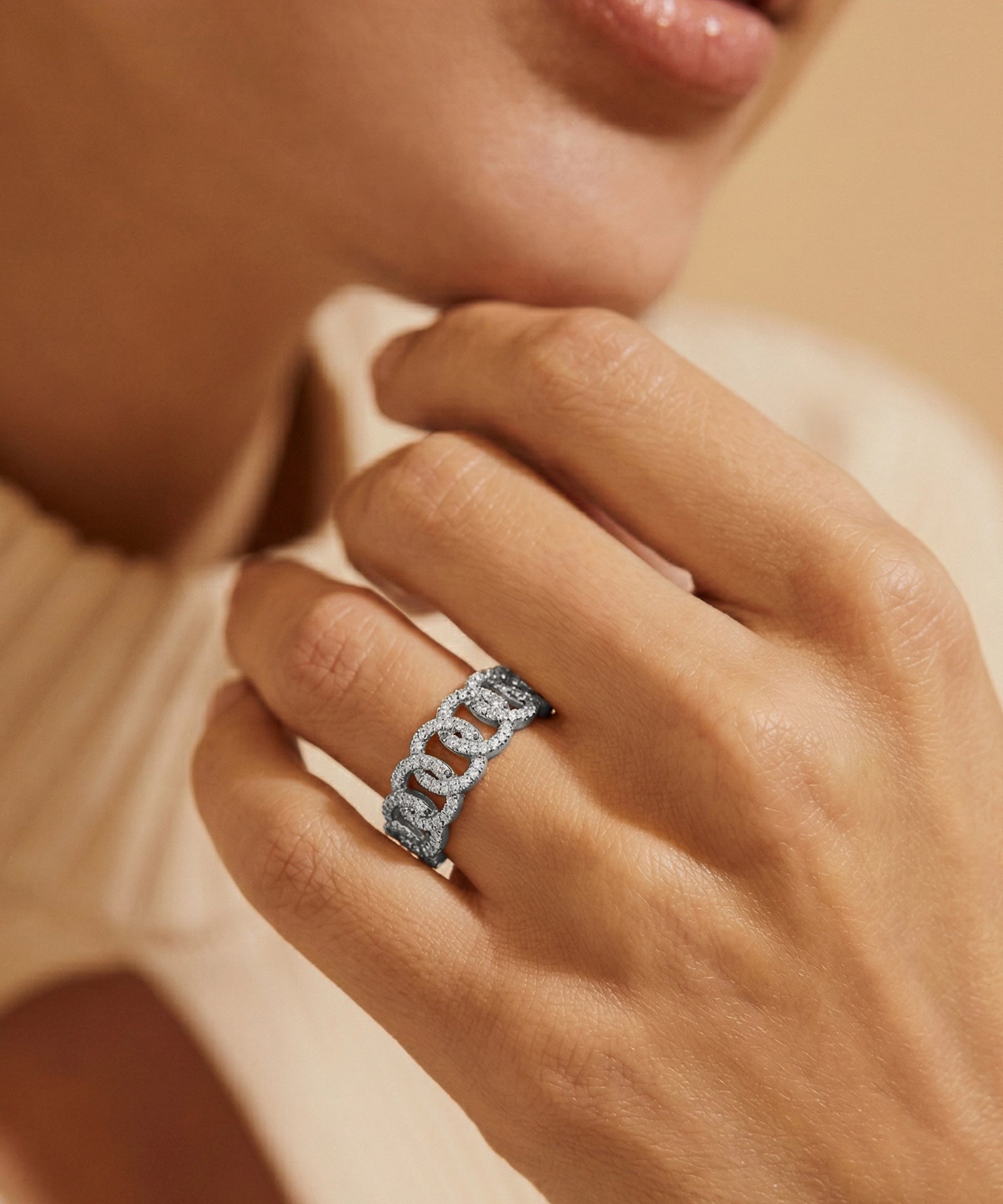 Close-up of a hand wearing a diamond ring with a soft focus background