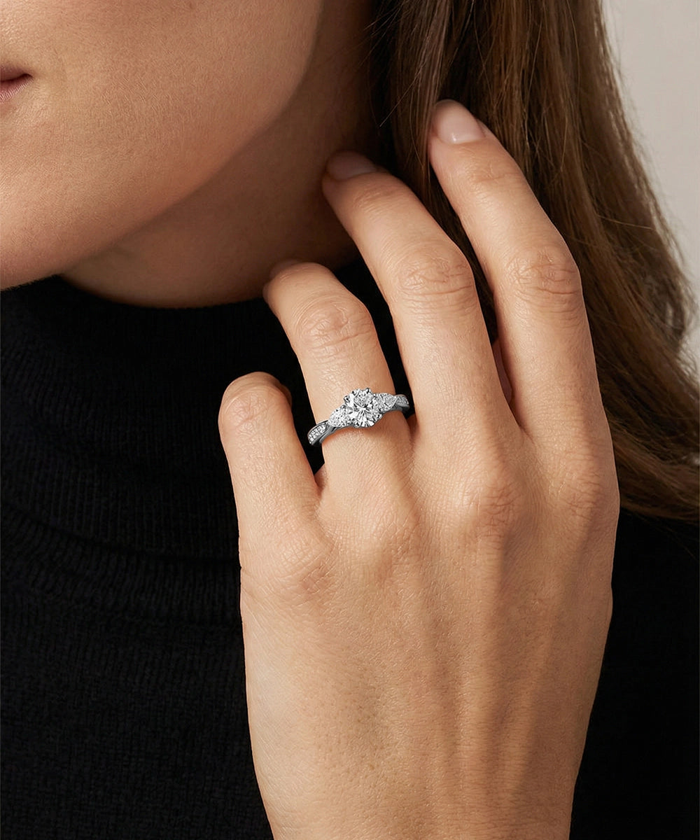 Close-up of a hand wearing a diamond ring with a blurred background