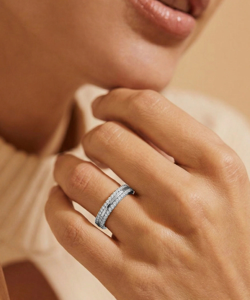 Close-up of a hand wearing a silver ring with a blurred background