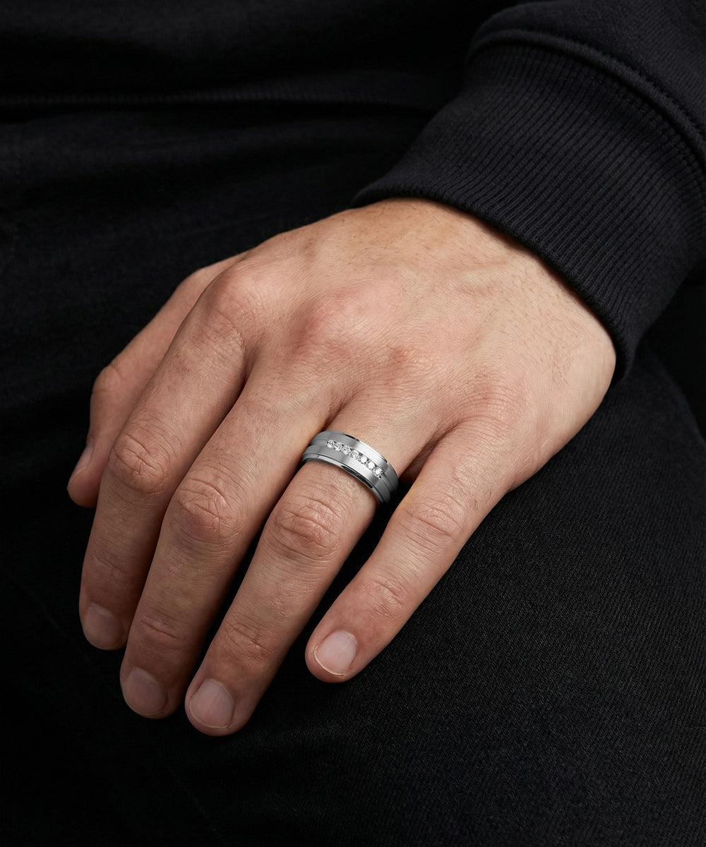 Hand wearing a gold ring on a black background