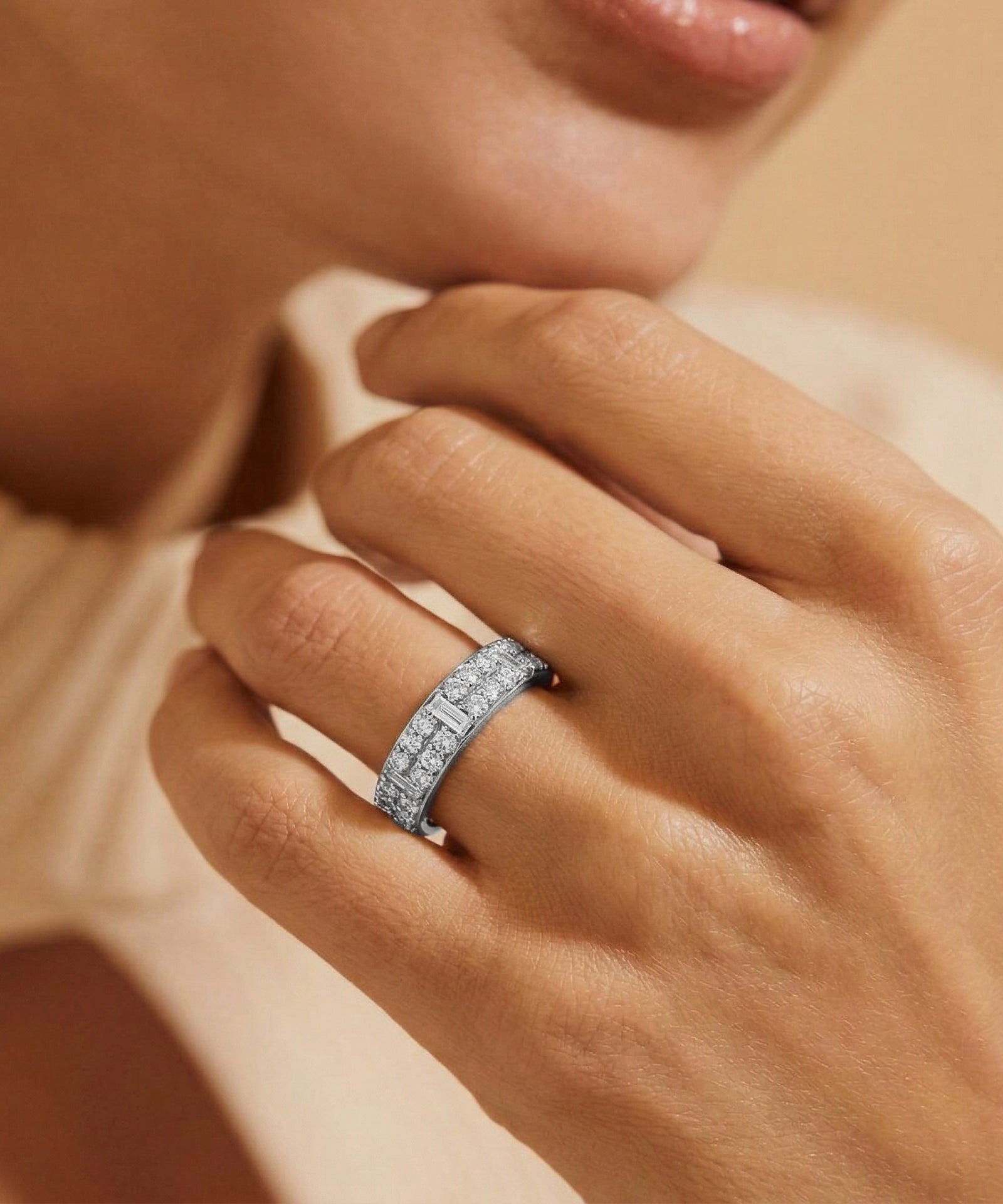 Close-up of a hand wearing a diamond ring with a soft focus background
