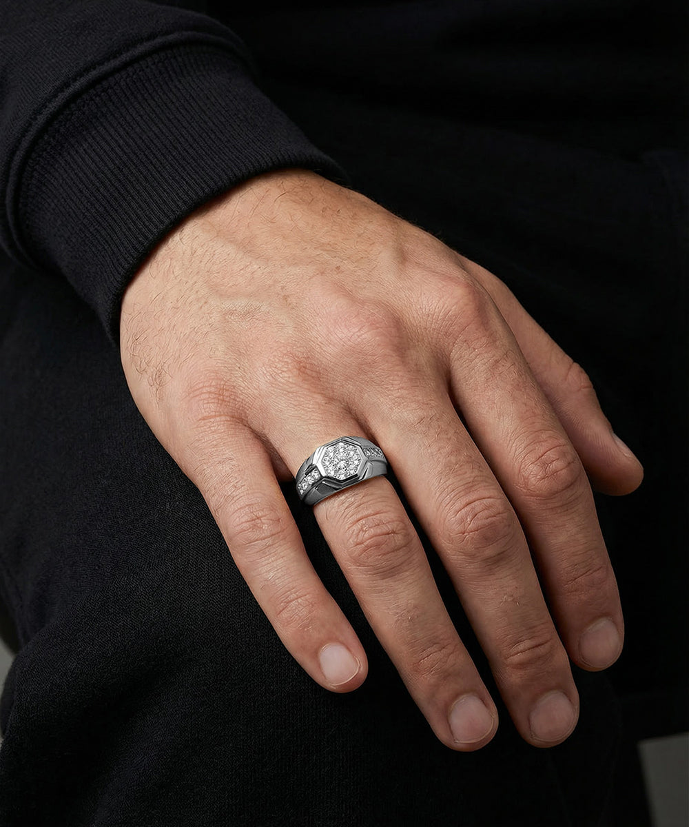 Hand wearing a silver ring with a diamond on a black background