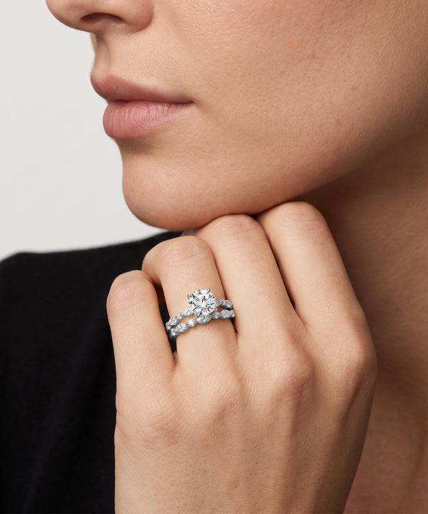 Close-up of a hand wearing a diamond ring with a neutral background