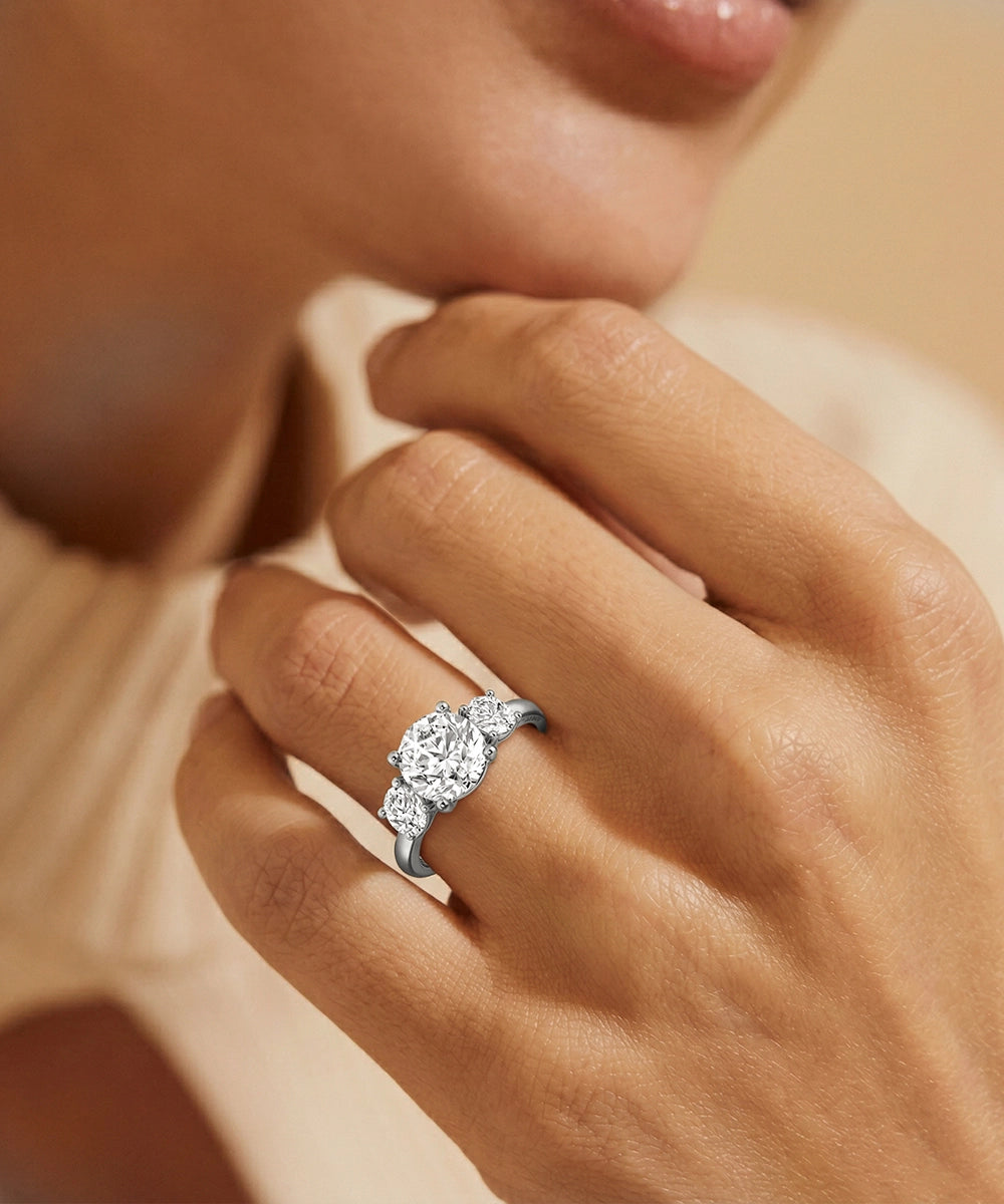 Close-up of a hand wearing a diamond ring with a soft focus background