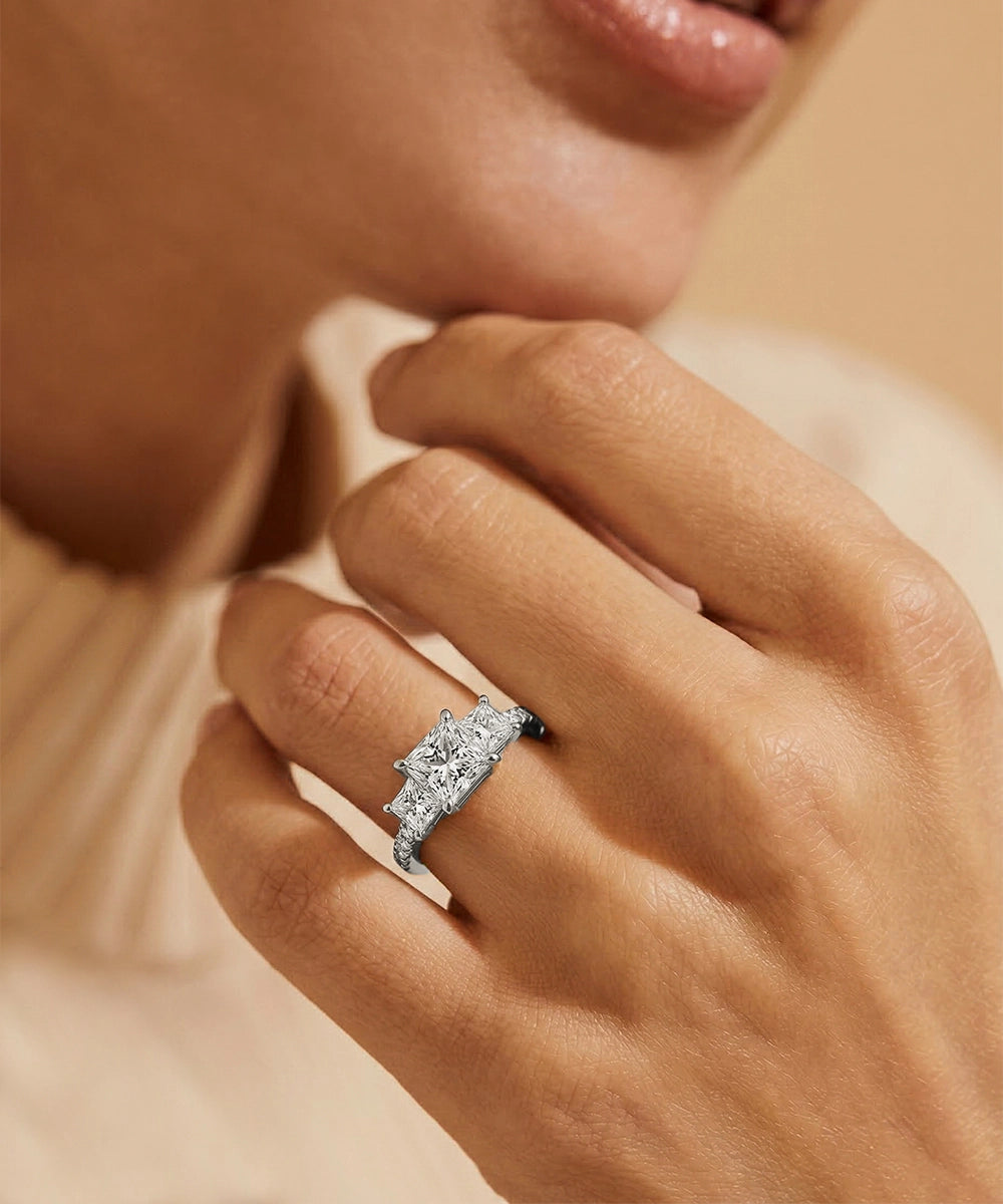 Close-up of a hand wearing a diamond ring with a soft focus background