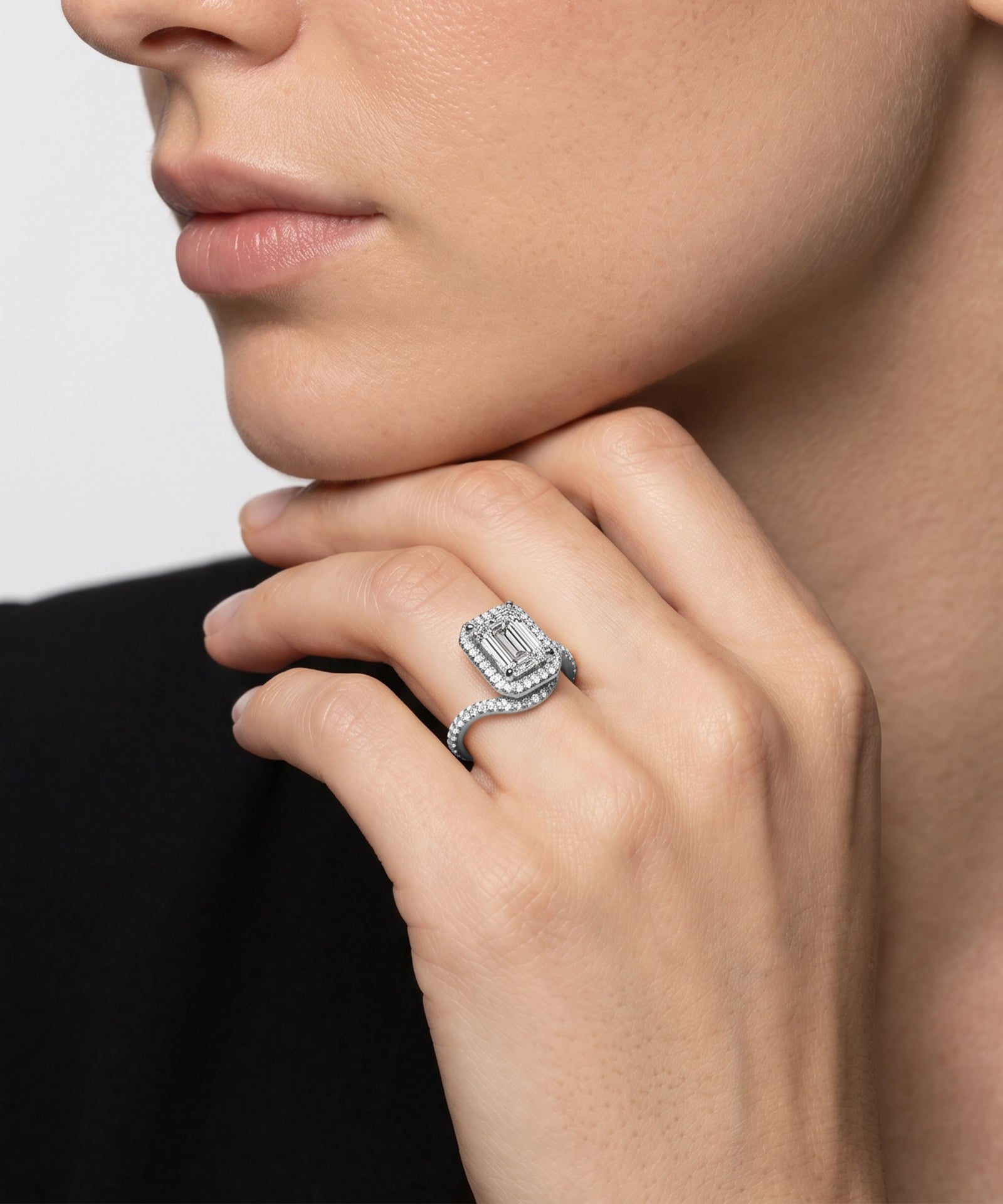 Close-up of a hand wearing a diamond ring with a blurred background