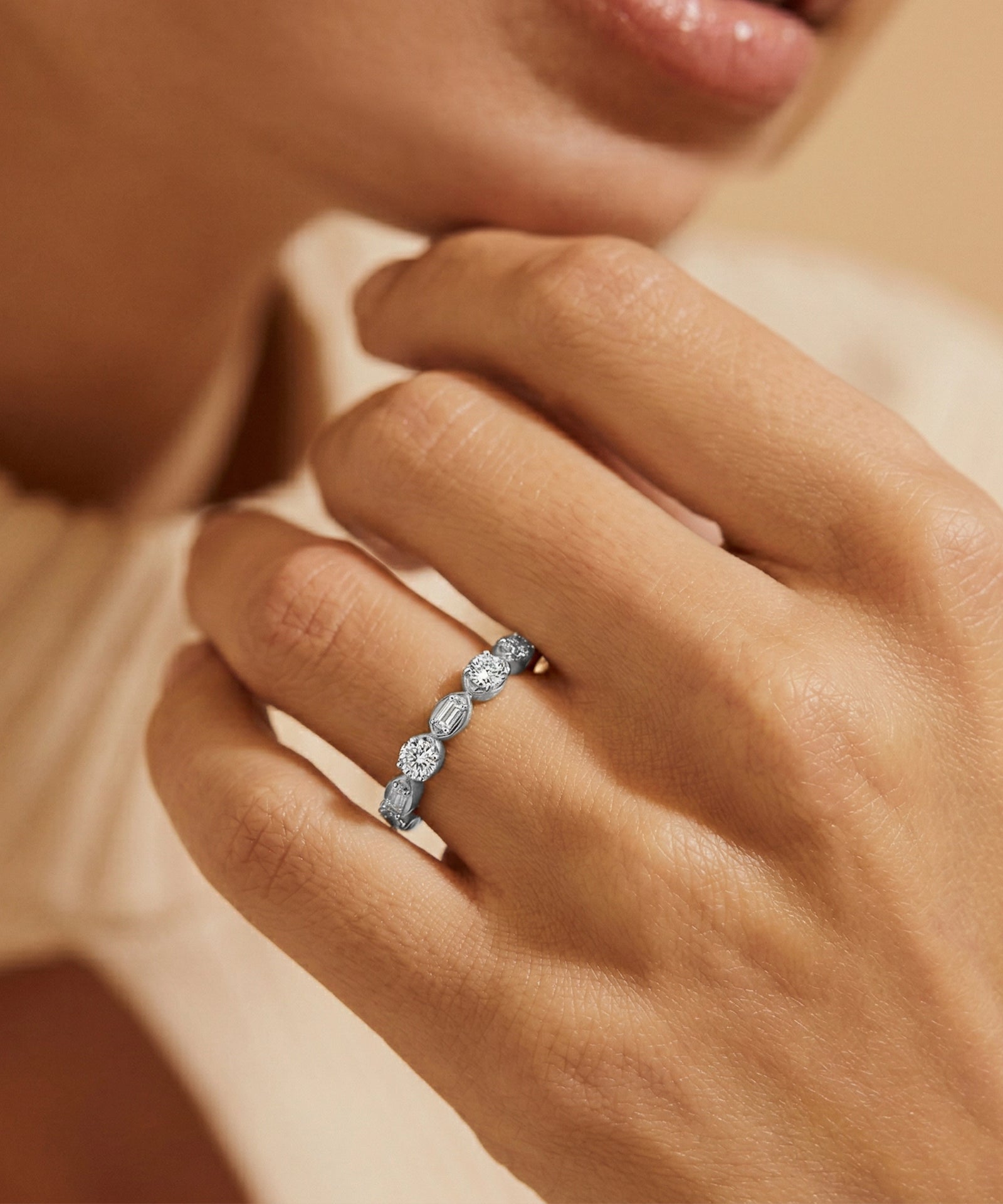 Close-up of a hand wearing a diamond ring with a soft focus background