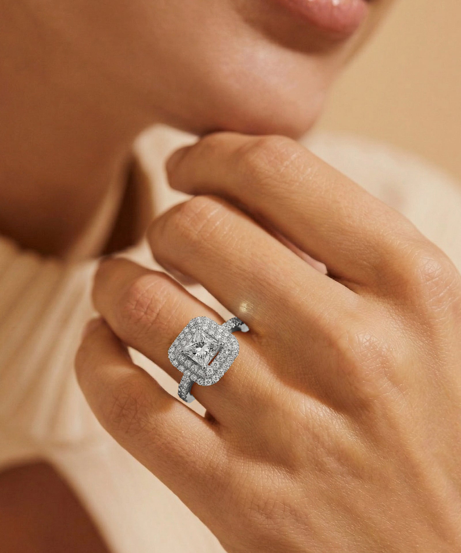 Close-up of a hand wearing a diamond ring with a soft focus background
