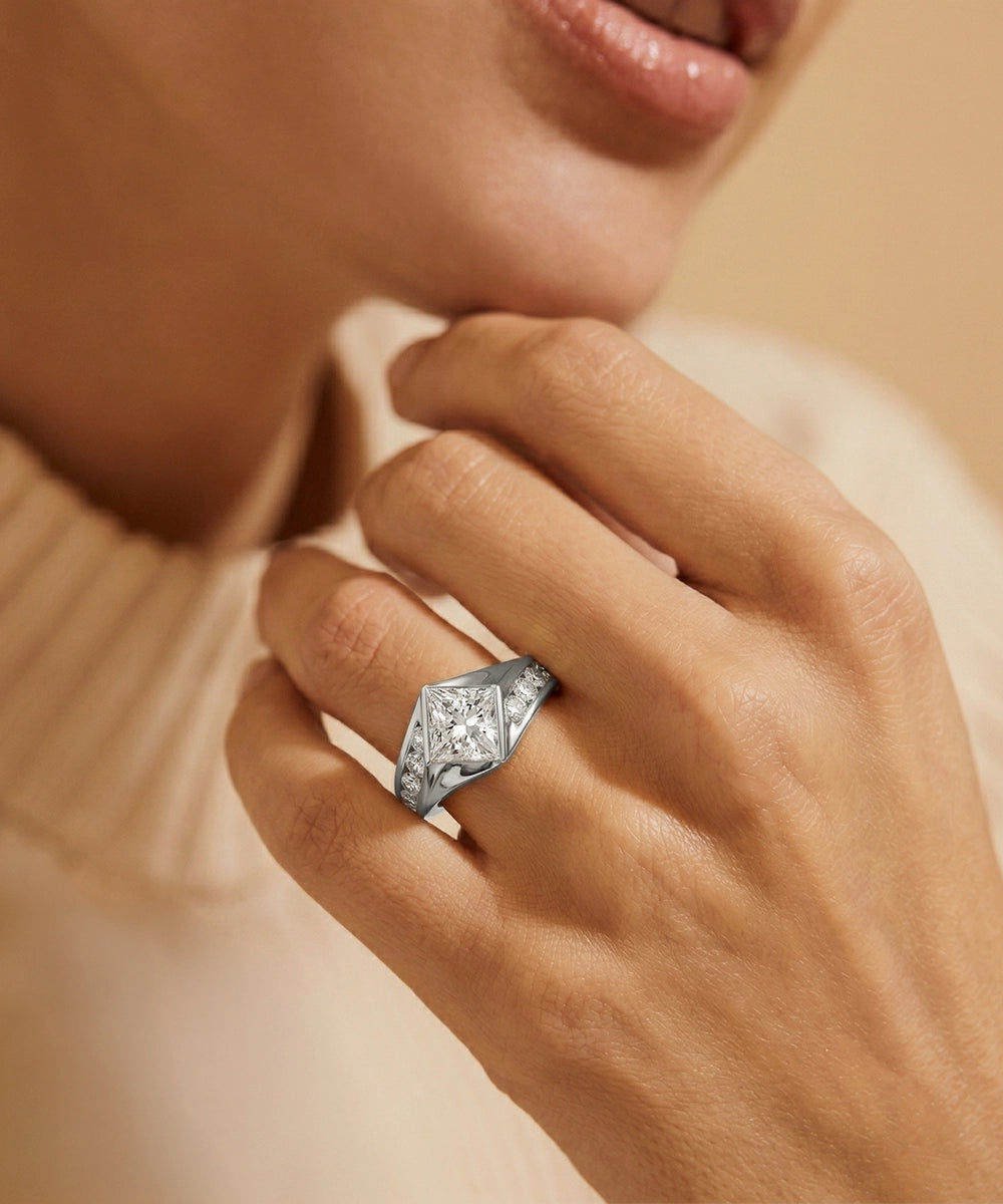 Close-up of a hand wearing a diamond ring with a soft background