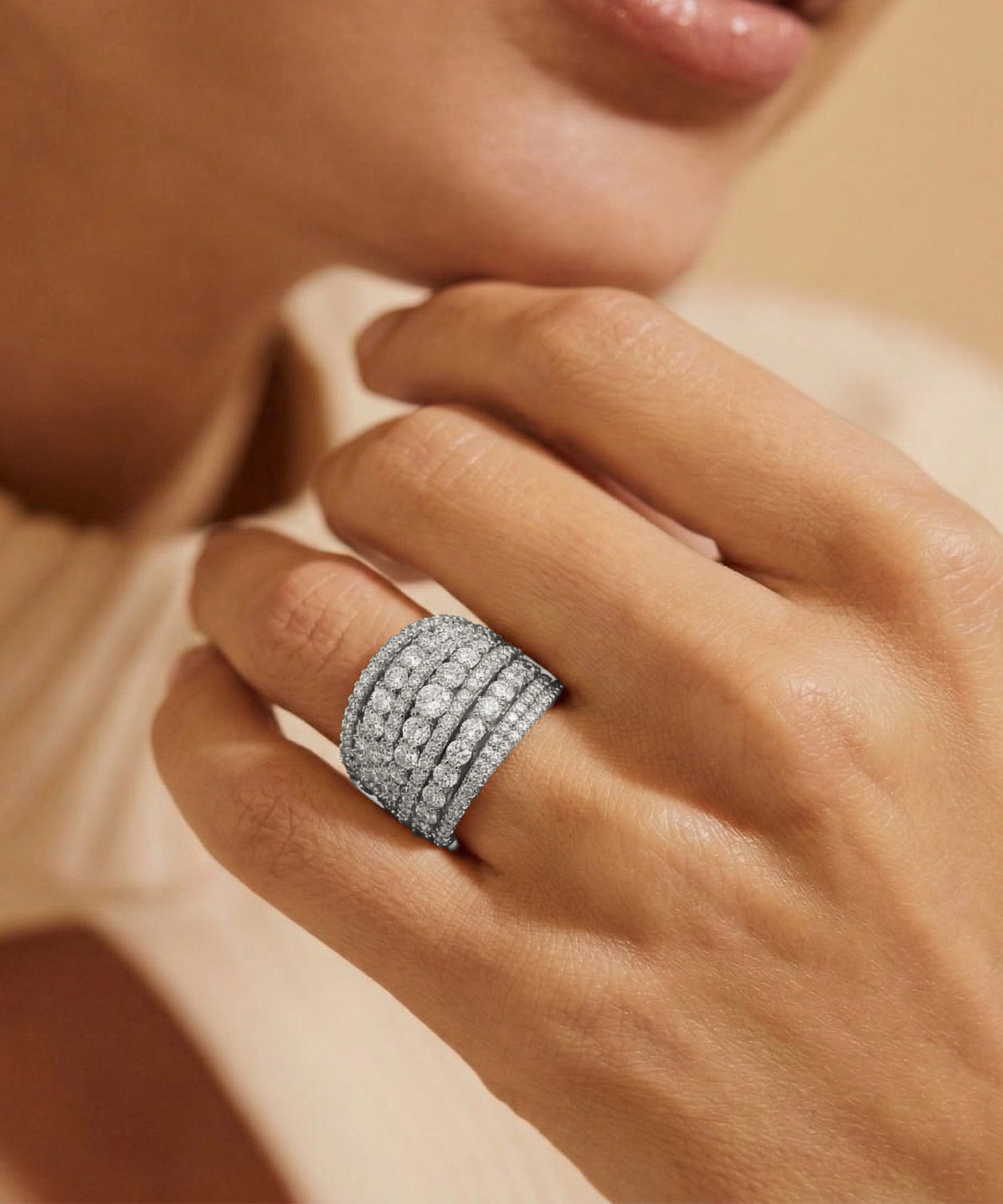 Close-up of a hand wearing a diamond ring with a soft focus background