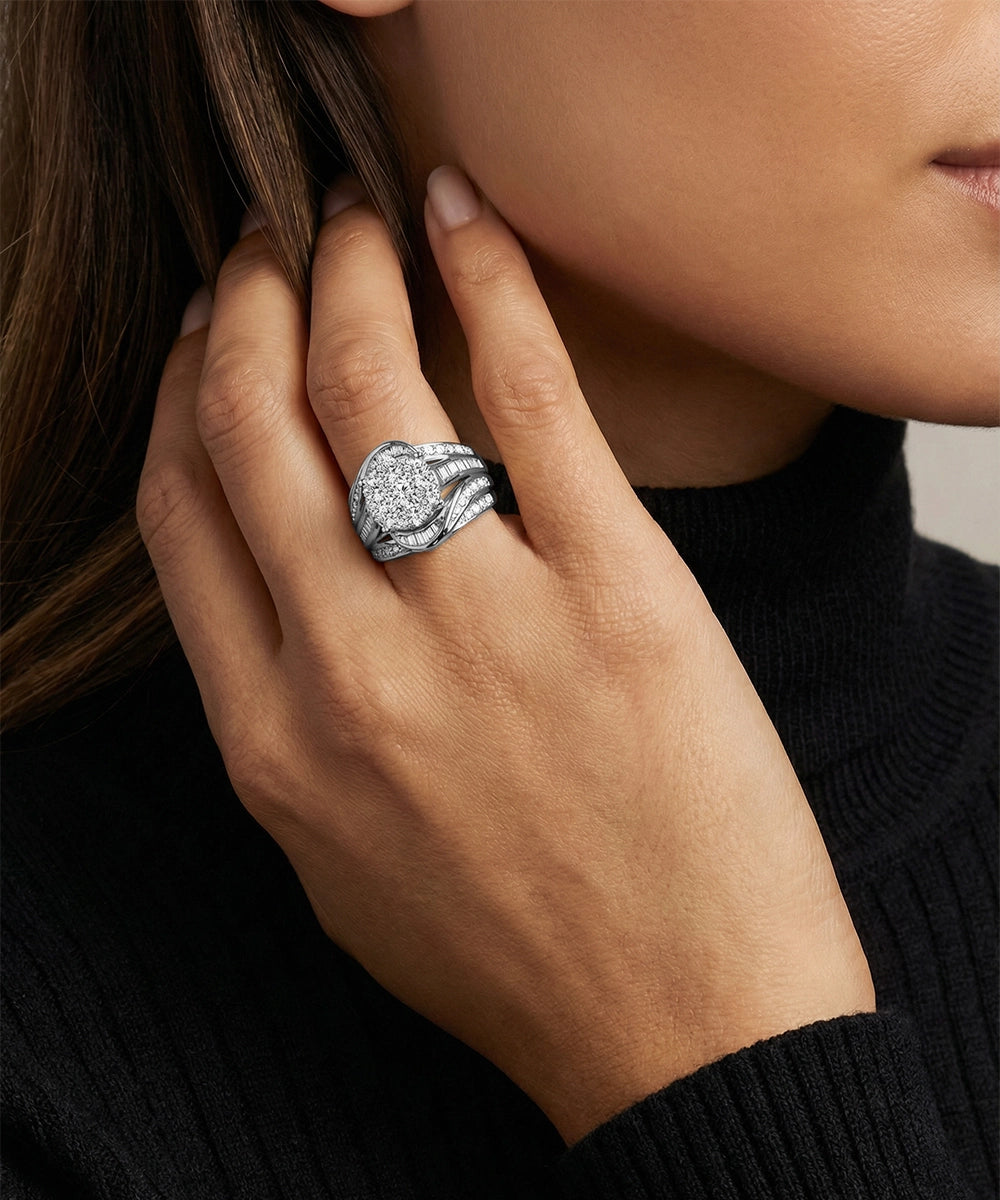 Close-up of a hand wearing a silver ring with a diamond, against a neutral background.