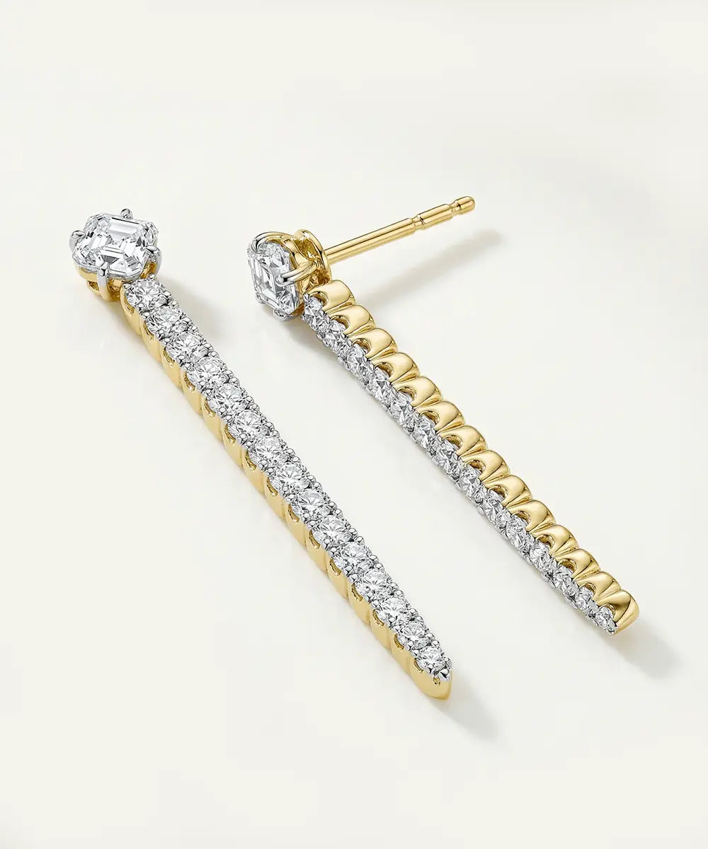 Pair of diamond earrings on a light beige background