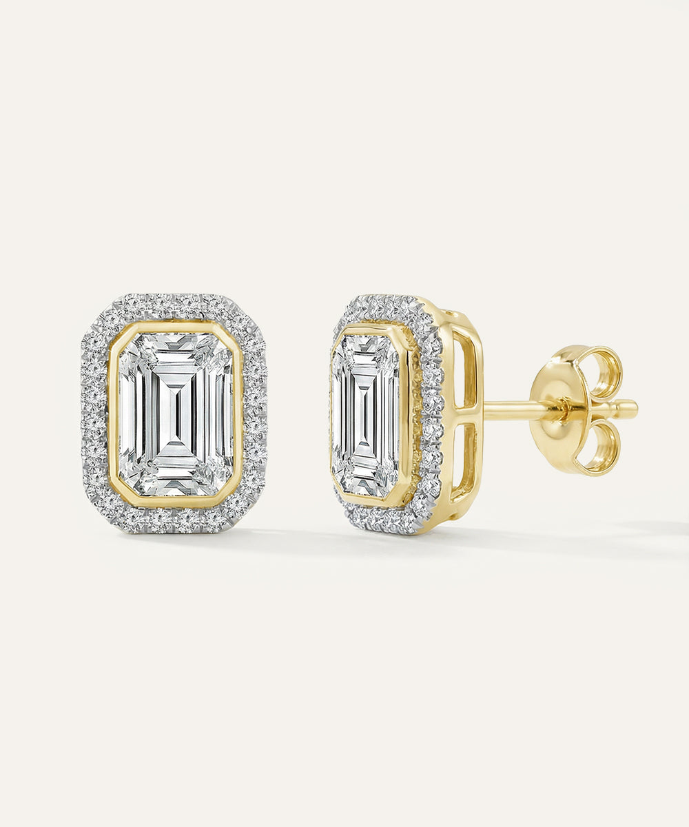 Gold emerald-cut earrings with diamond accents on a white background