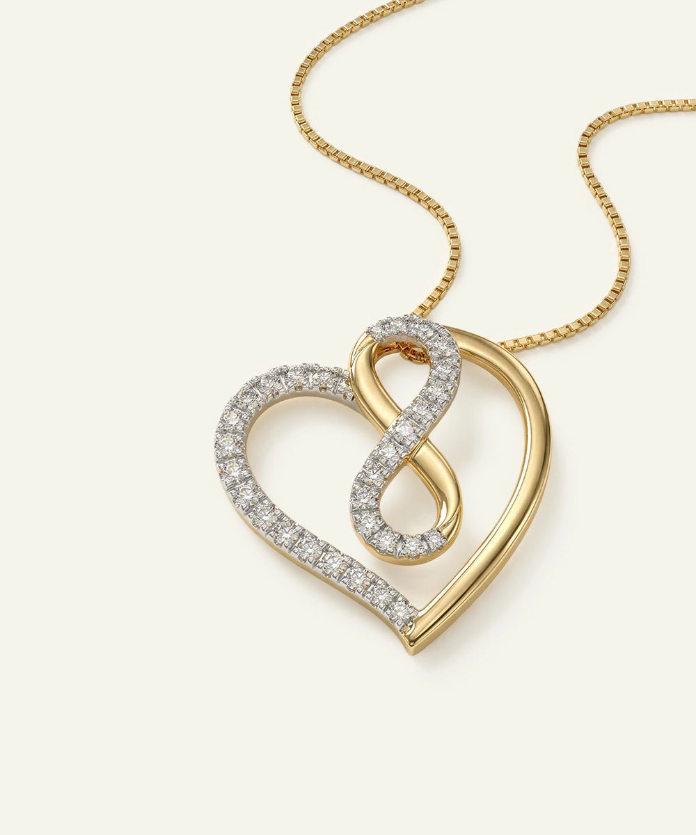 Gold necklace with a heart and infinity symbol pendant on a light beige background