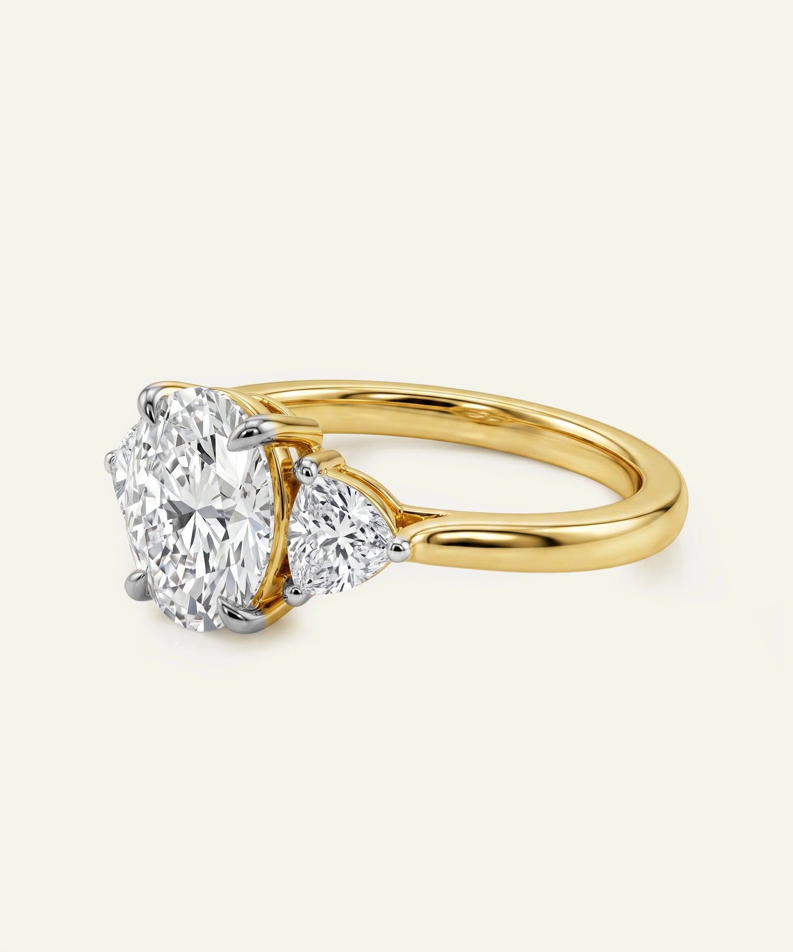 Gold ring with three diamond stones on a light gray background