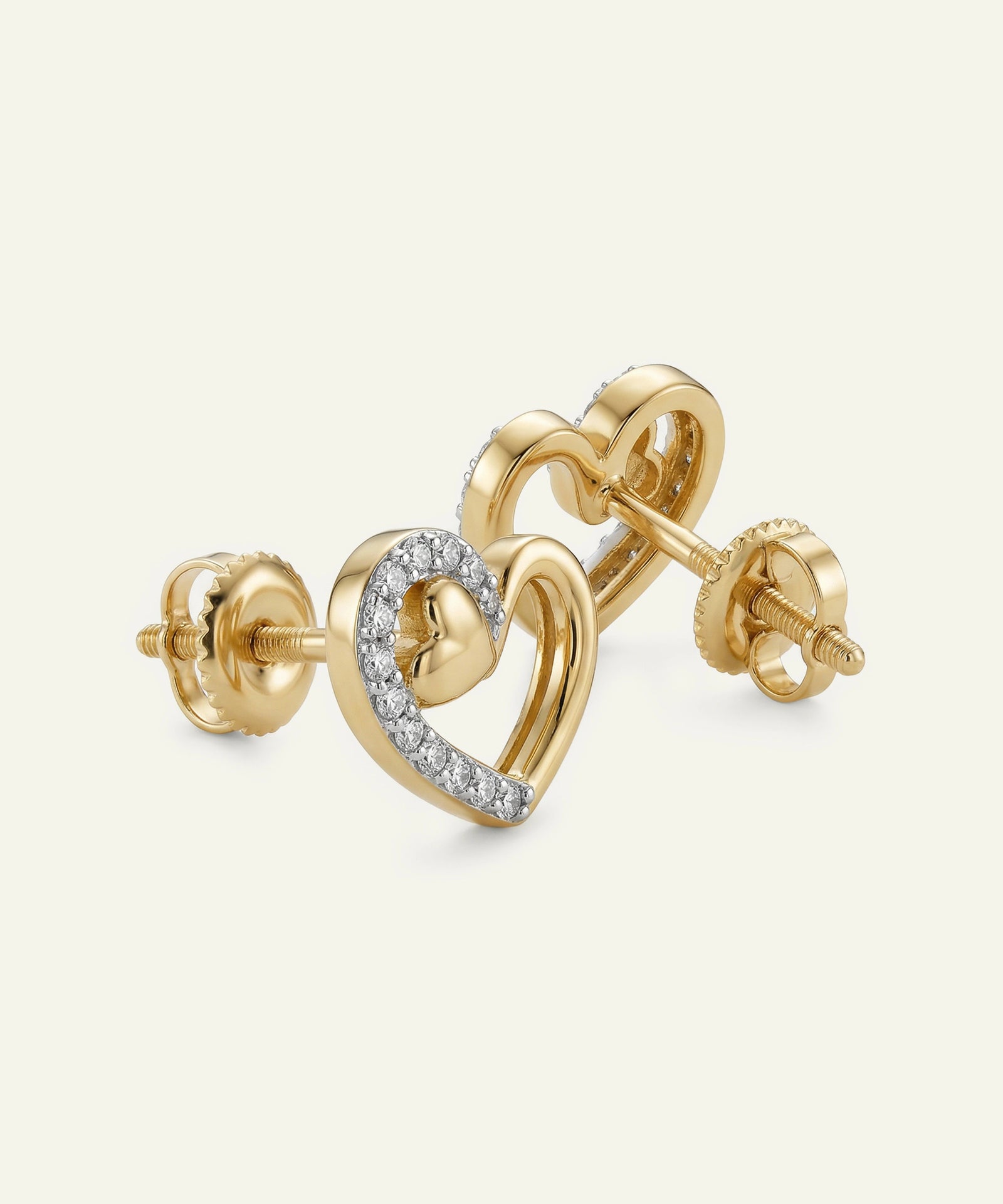 Gold heart-shaped earrings with diamond accents on a white background