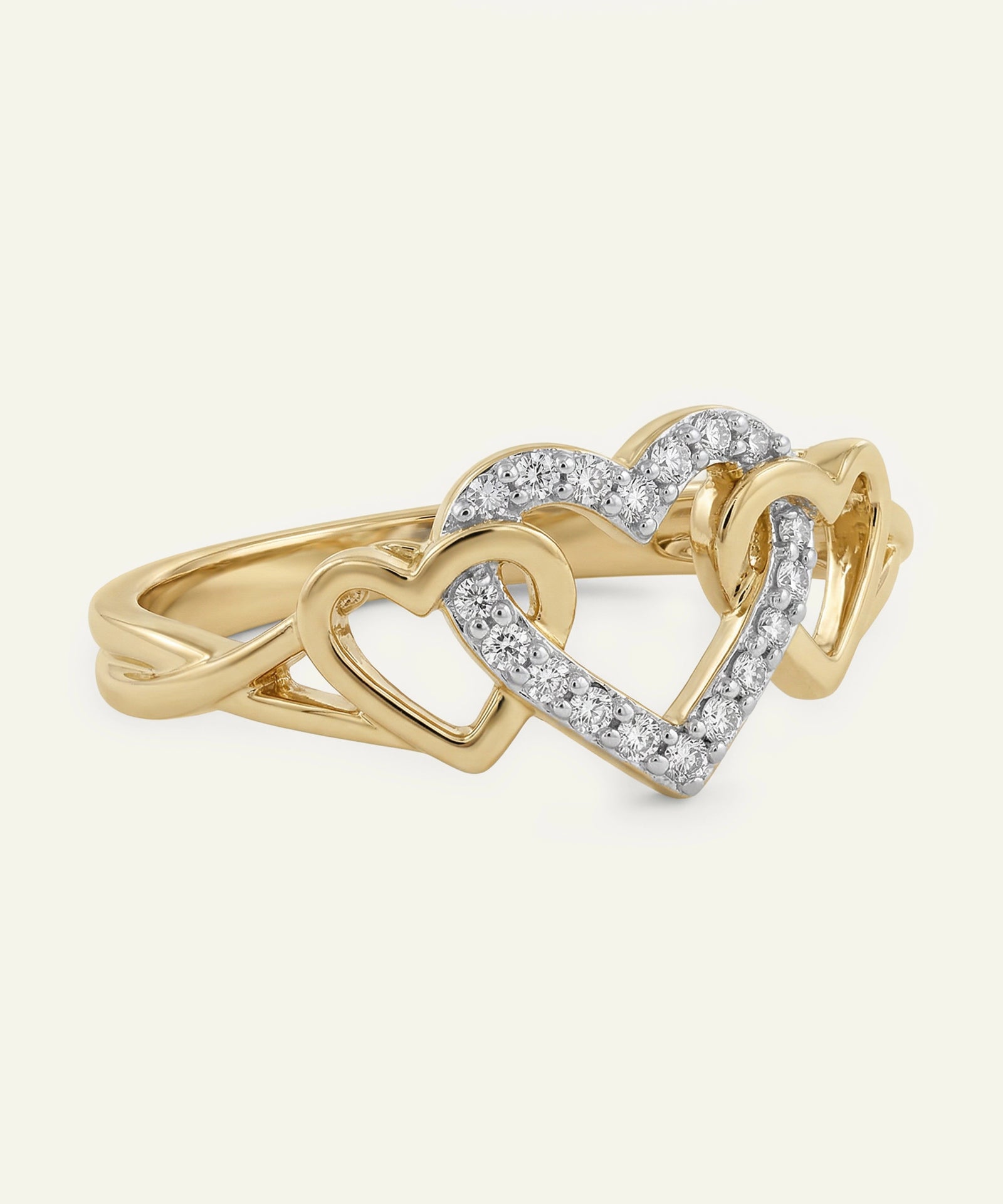 Gold ring with interlocking heart designs and diamond accents on a white background