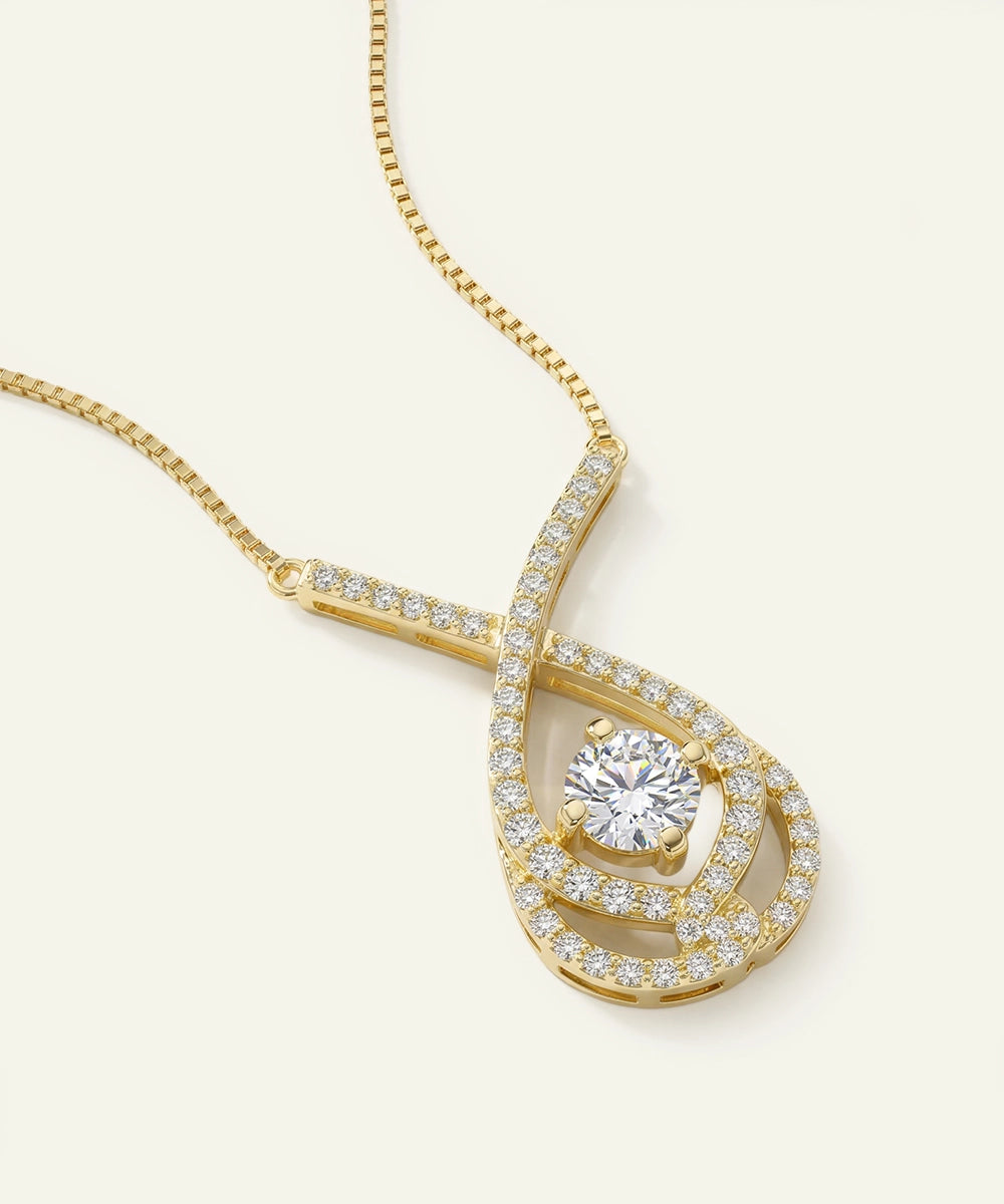 Gold necklace with a diamond pendant on a light beige background