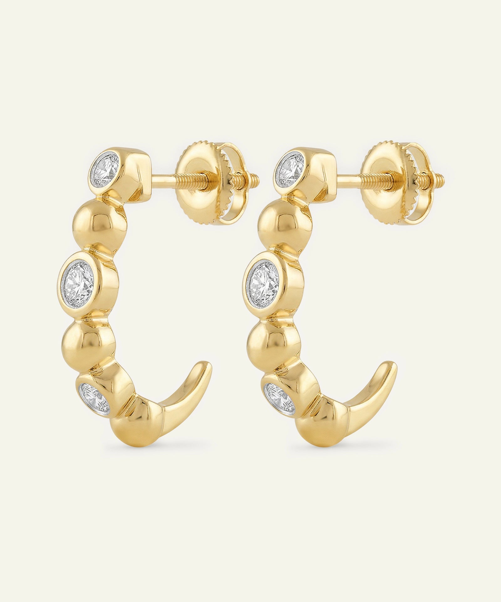 Gold hoop earrings with diamond accents on a white background
