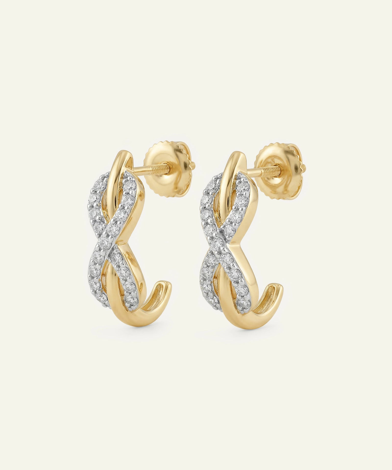 Gold and silver earrings with a twisted design on a white background