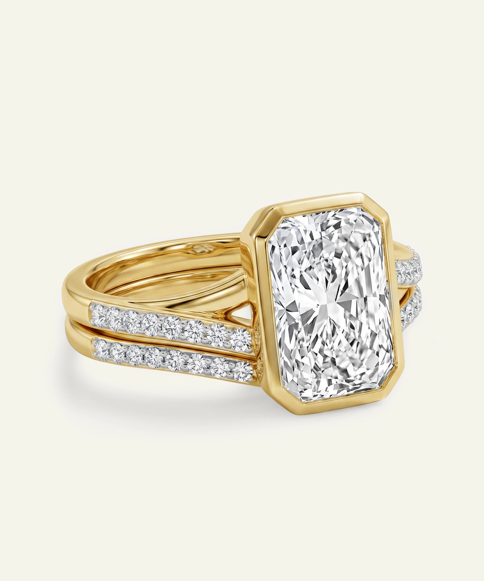 Gold ring with a large diamond and smaller diamonds on the band against a white background
