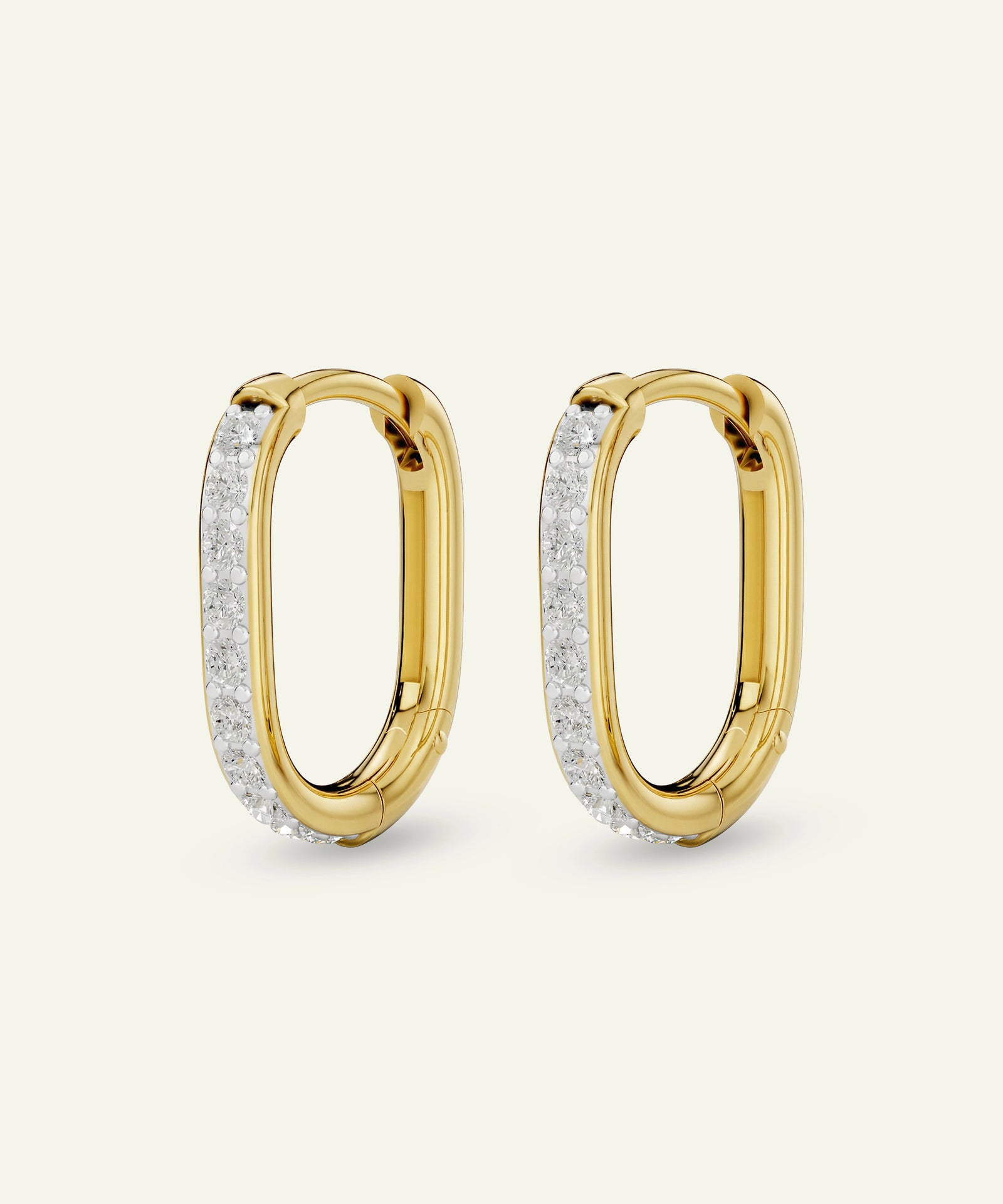 Gold hoop earrings with diamond accents on a light beige background