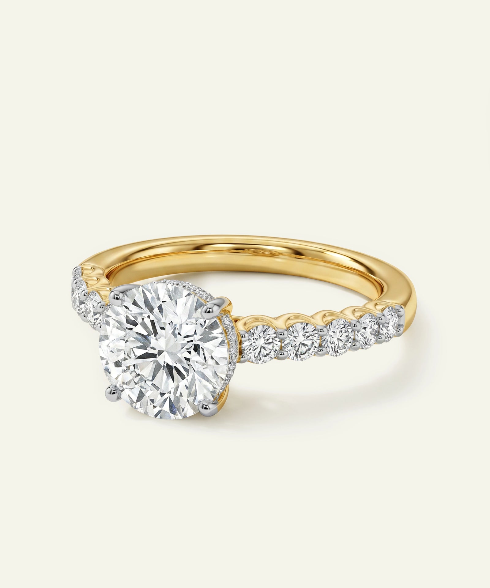 Gold ring with a large diamond and smaller diamonds on the band against a white background
