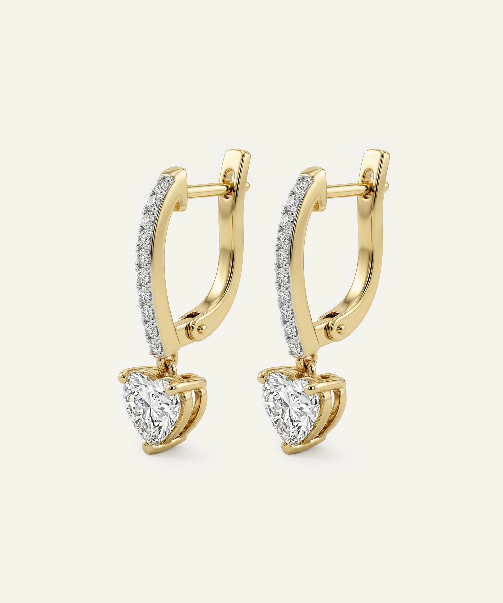 Gold hoop earrings with heart-shaped gemstones on a light gray background
