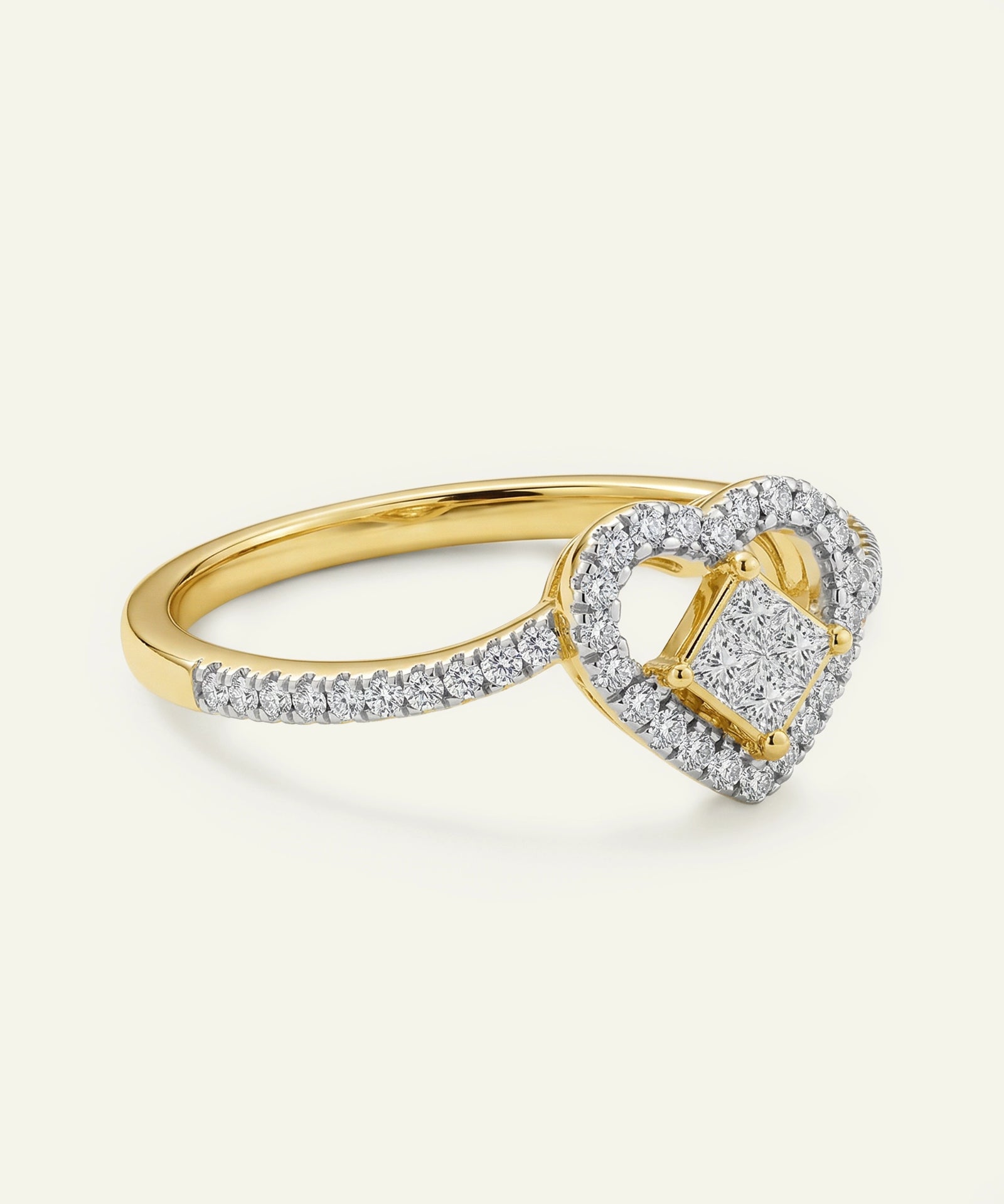 Gold ring with a heart-shaped diamond on a white background