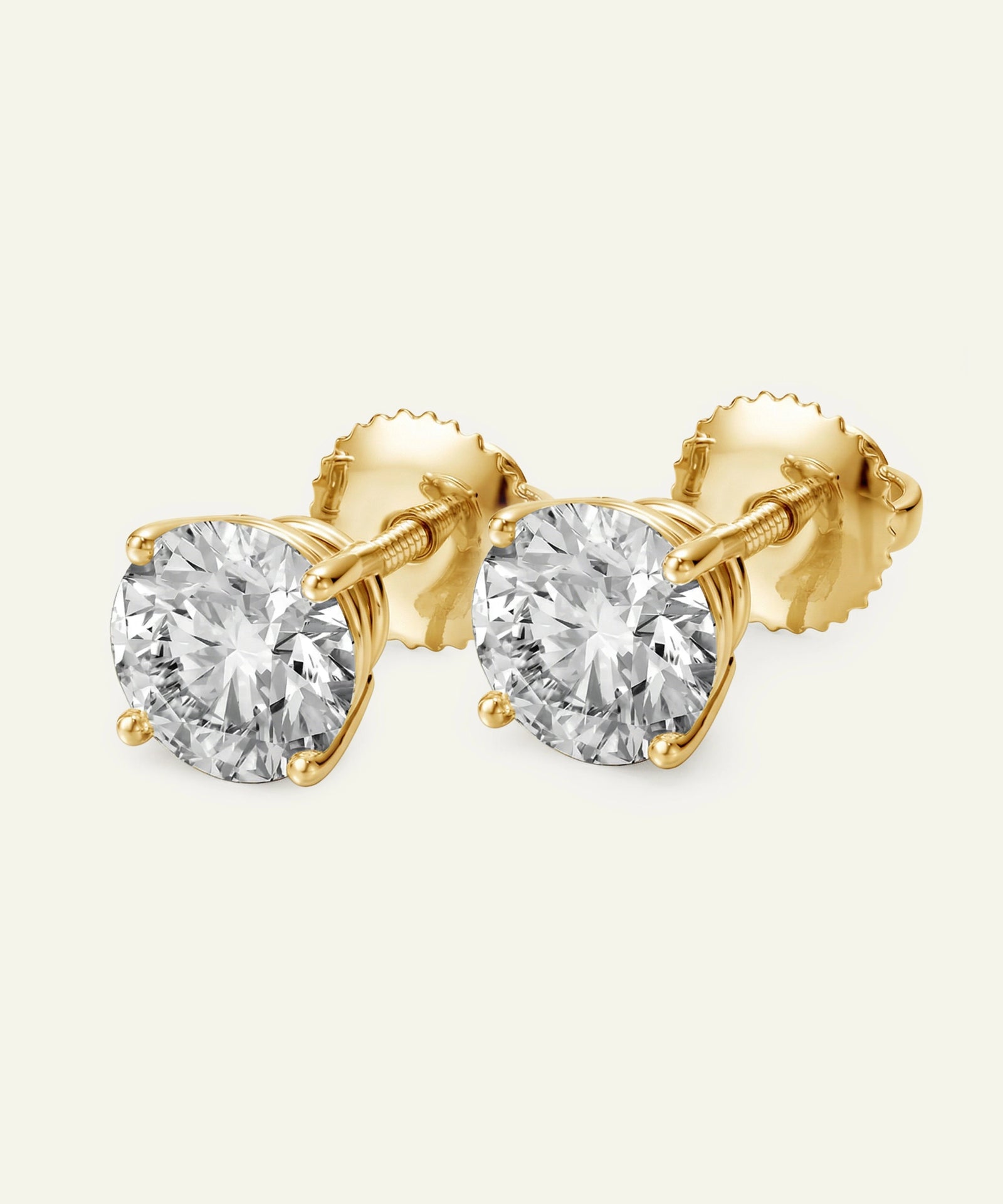 Gold stud earrings with clear gemstones on a white background