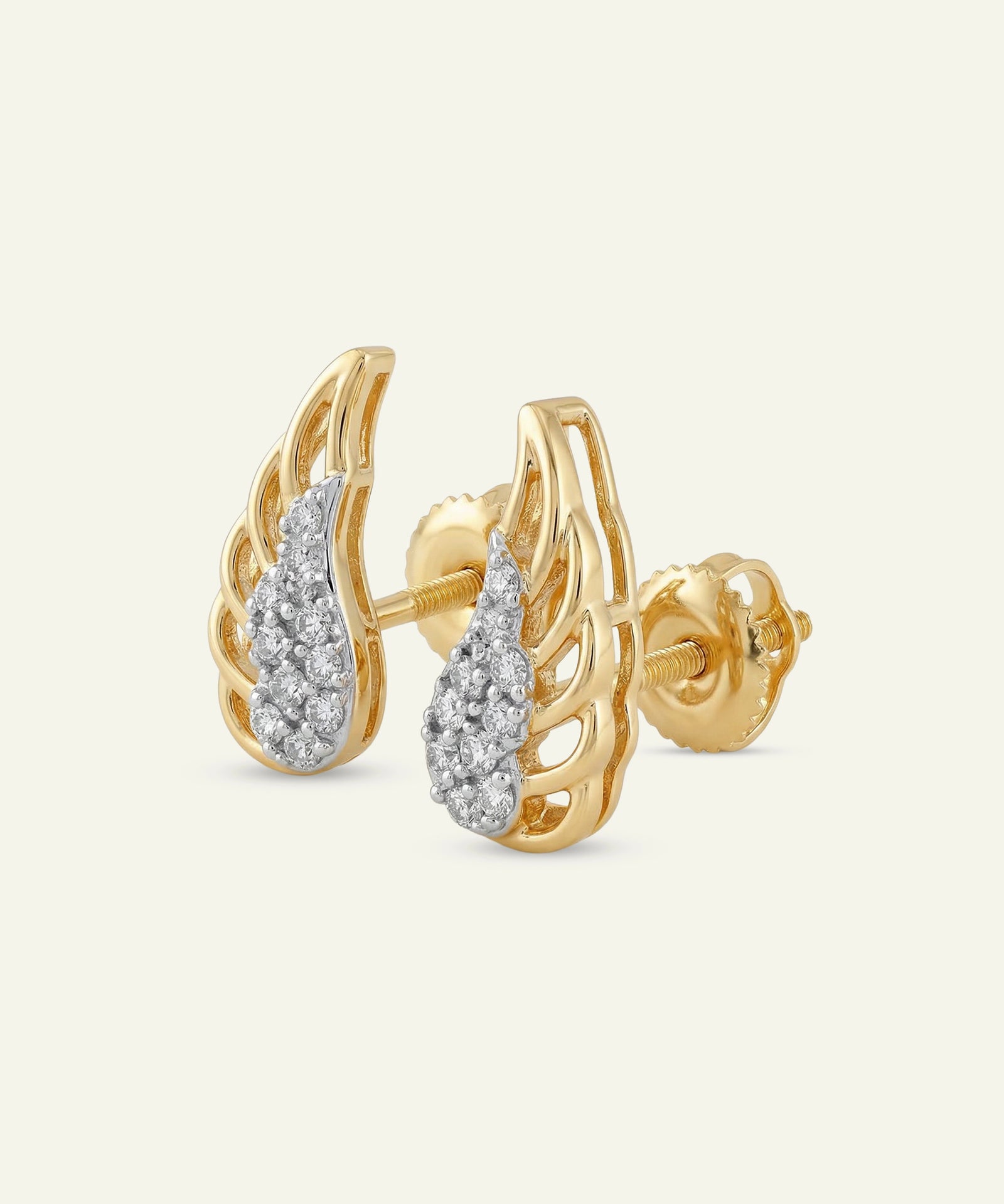 Gold earrings with diamond accents on a light beige background