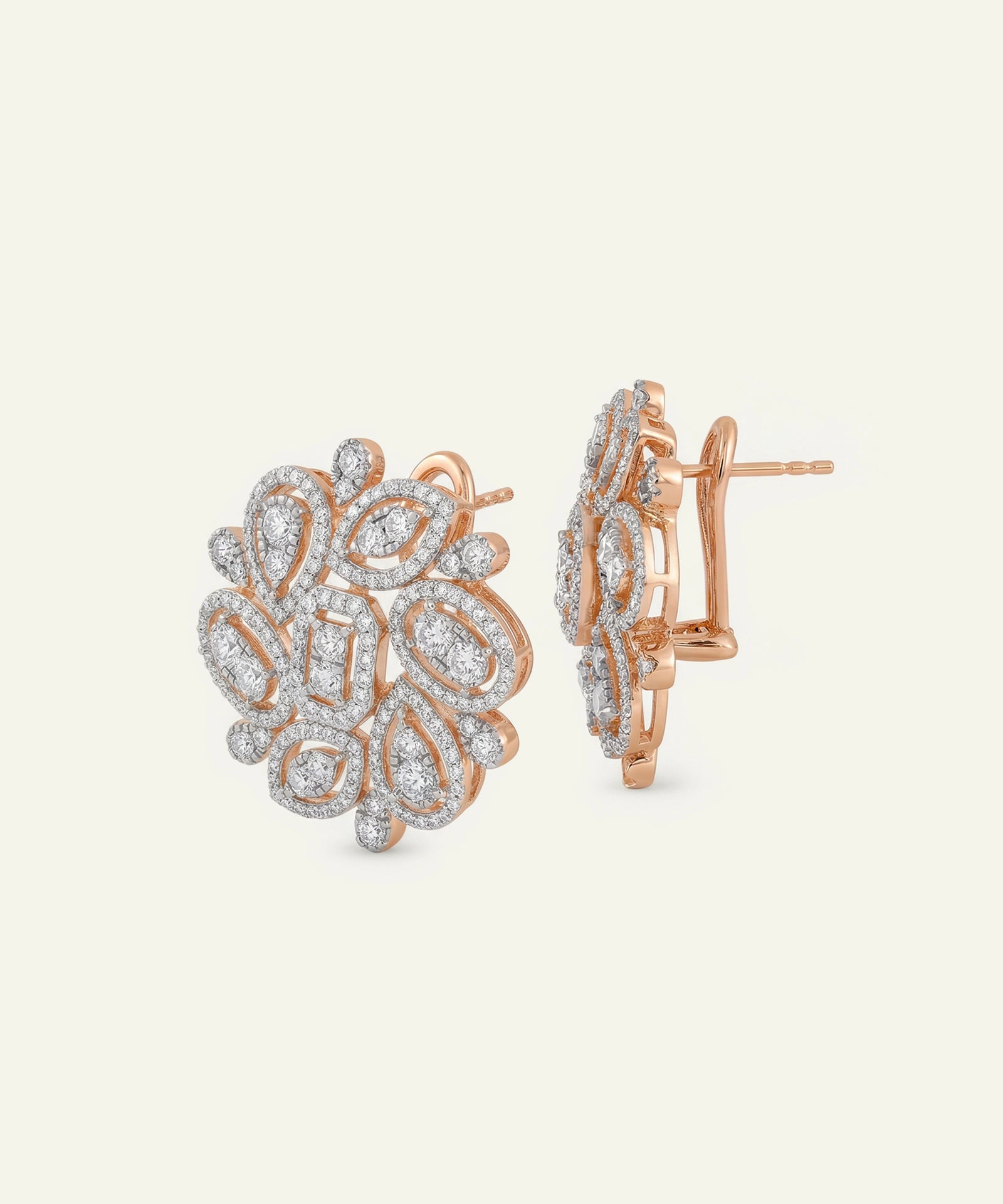 Rose gold earrings with intricate design on a light beige background